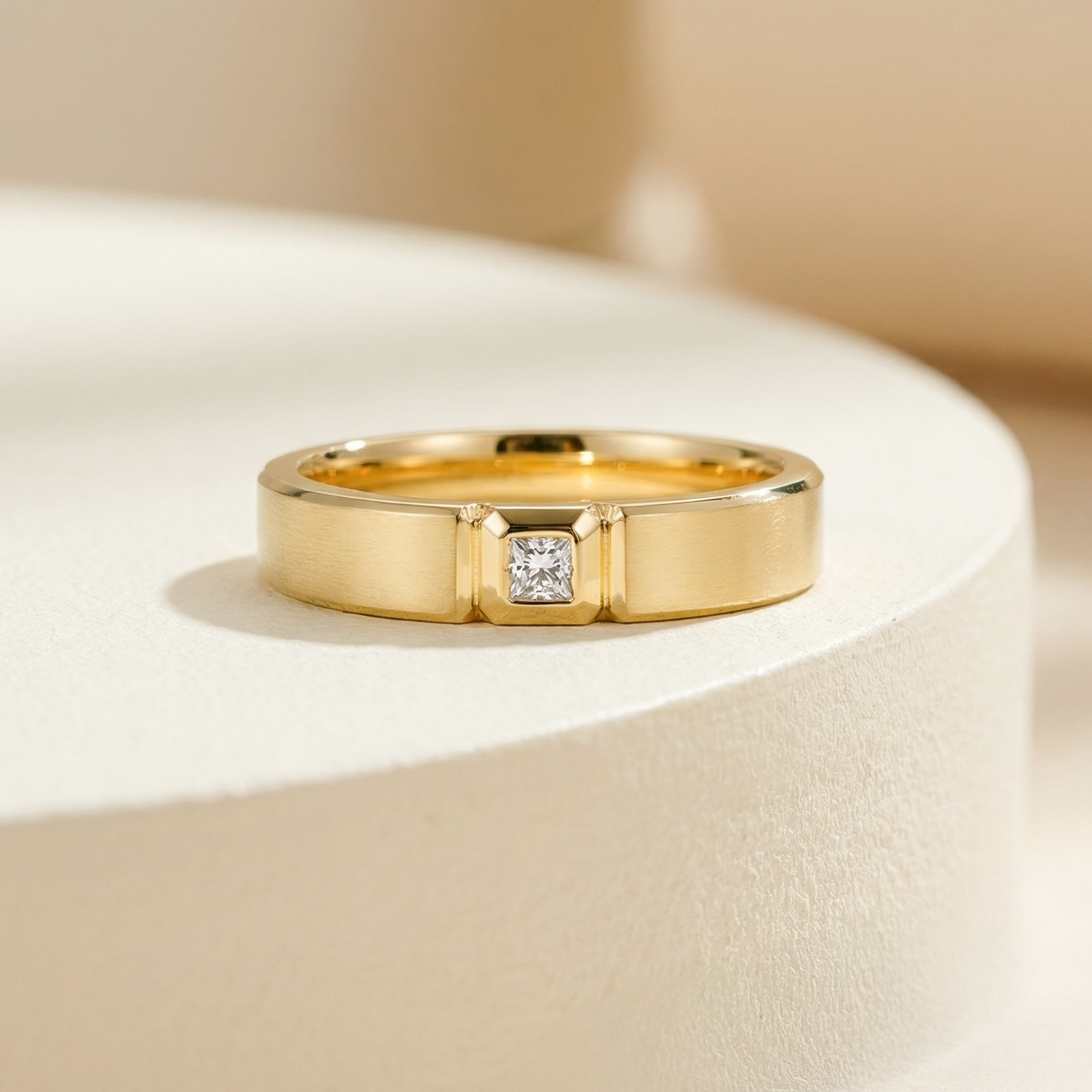 黃金色現代幾何天然鑽石結婚戒指近拍特寫。清晰可見戒身中央精湛的立體方形倒角鑲座，將一顆 0.09ct 天然鑽石穩穩包裹其中。設計充滿型格與份量感，表面散發細緻的拉絲金屬光澤。