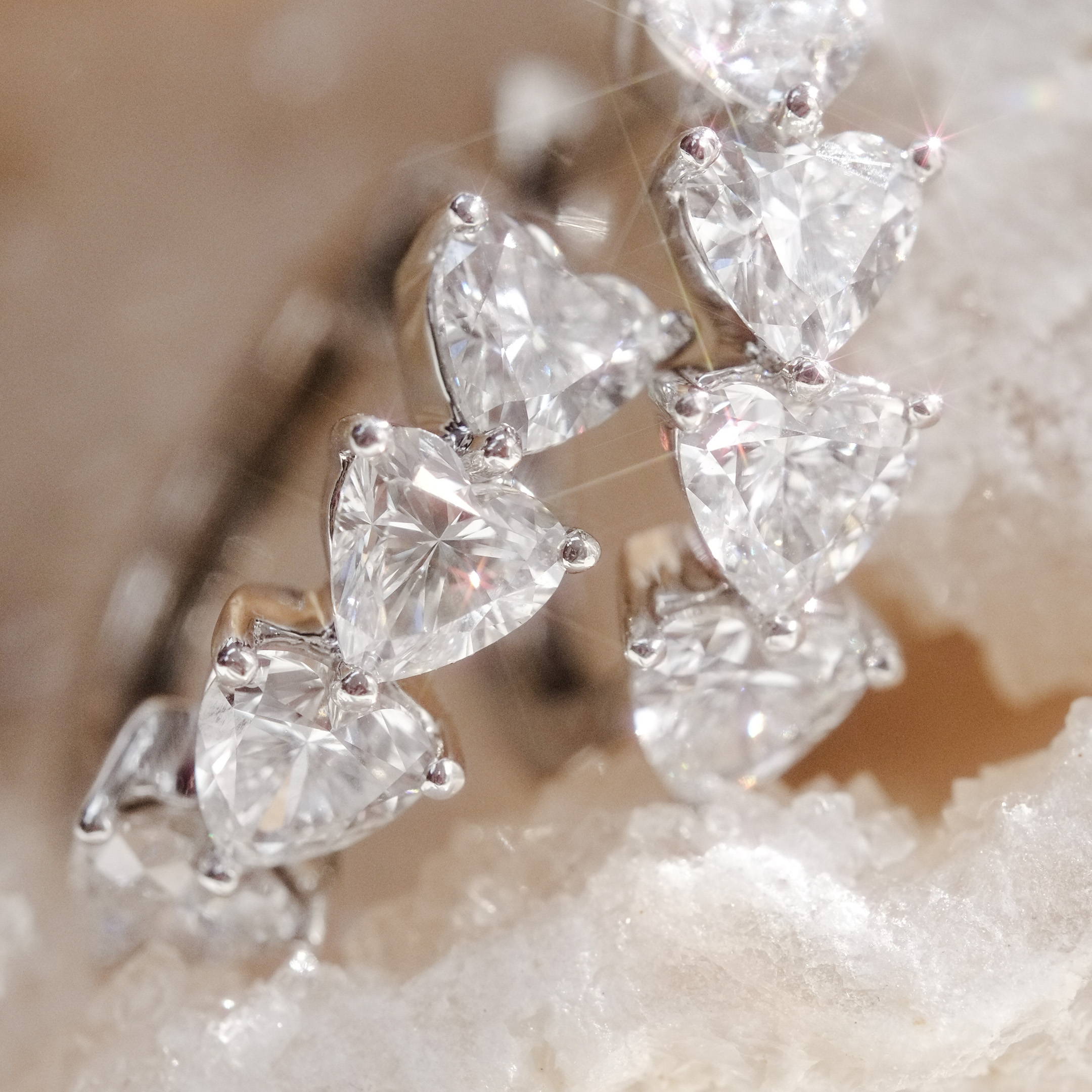 detail view of heart diamond hoop earrings showing prong setting 
