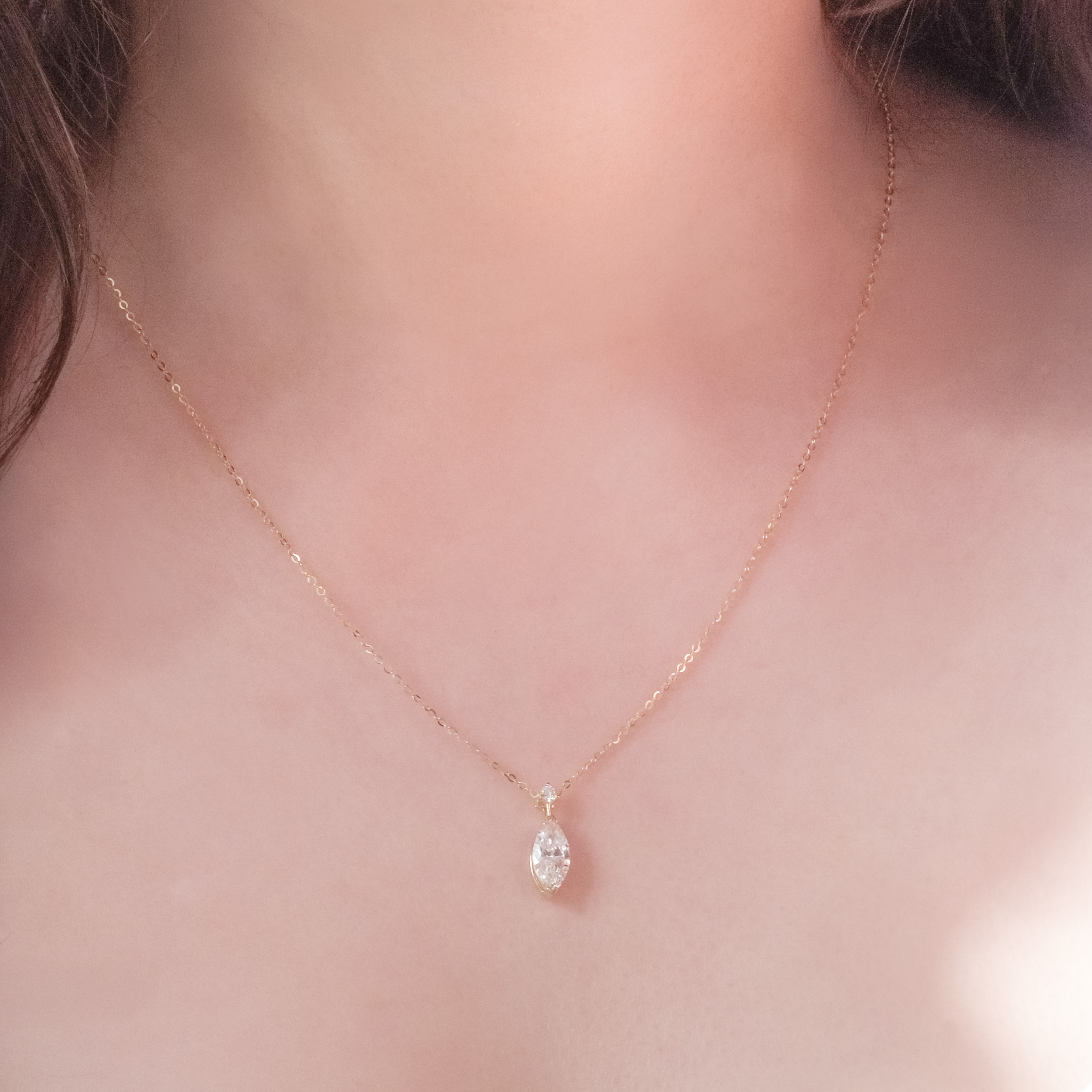 模特佩戴 1ct 馬眼形單鑽垂墜項鍊，展示 18.8mm 流線設計修飾頸部線條效果