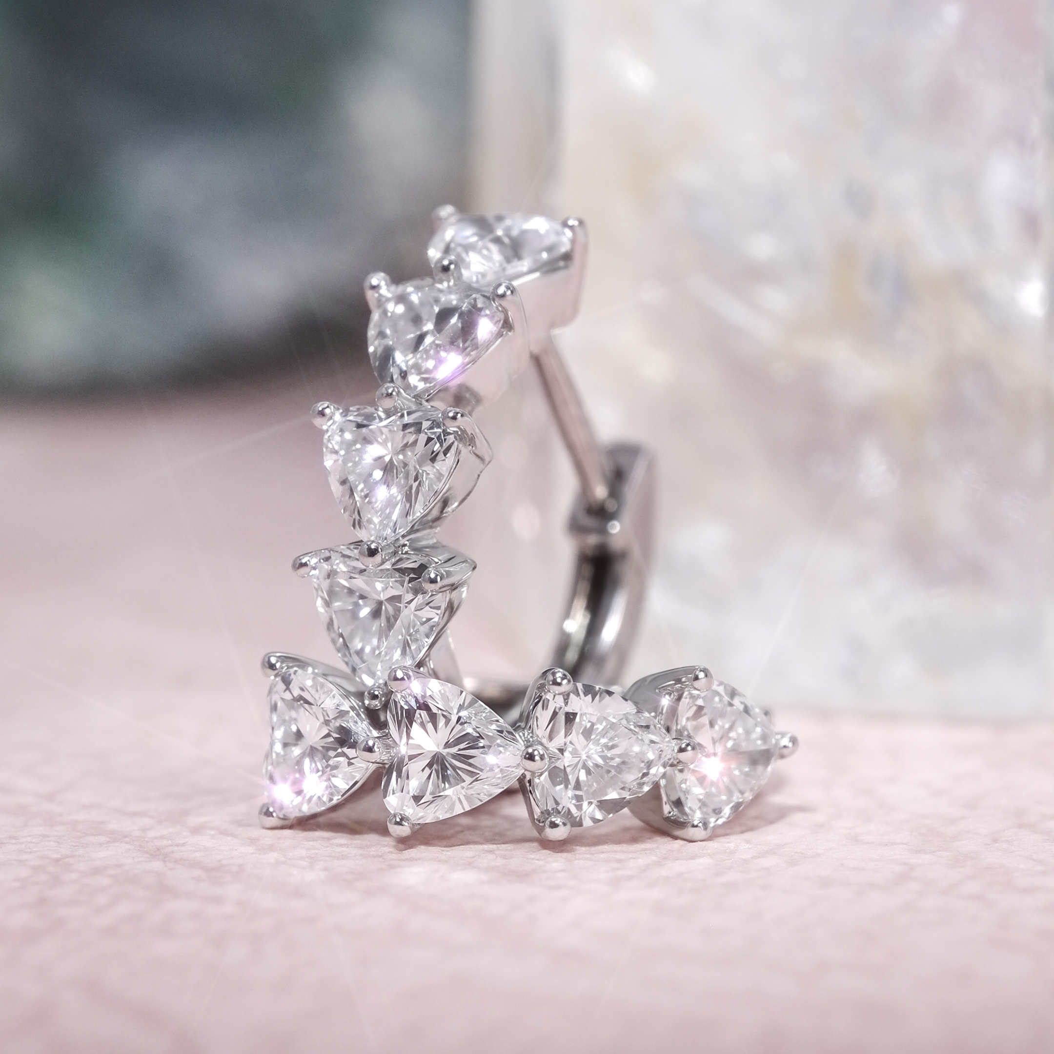 detail view of heart diamond hoop earrings showing prong setting 