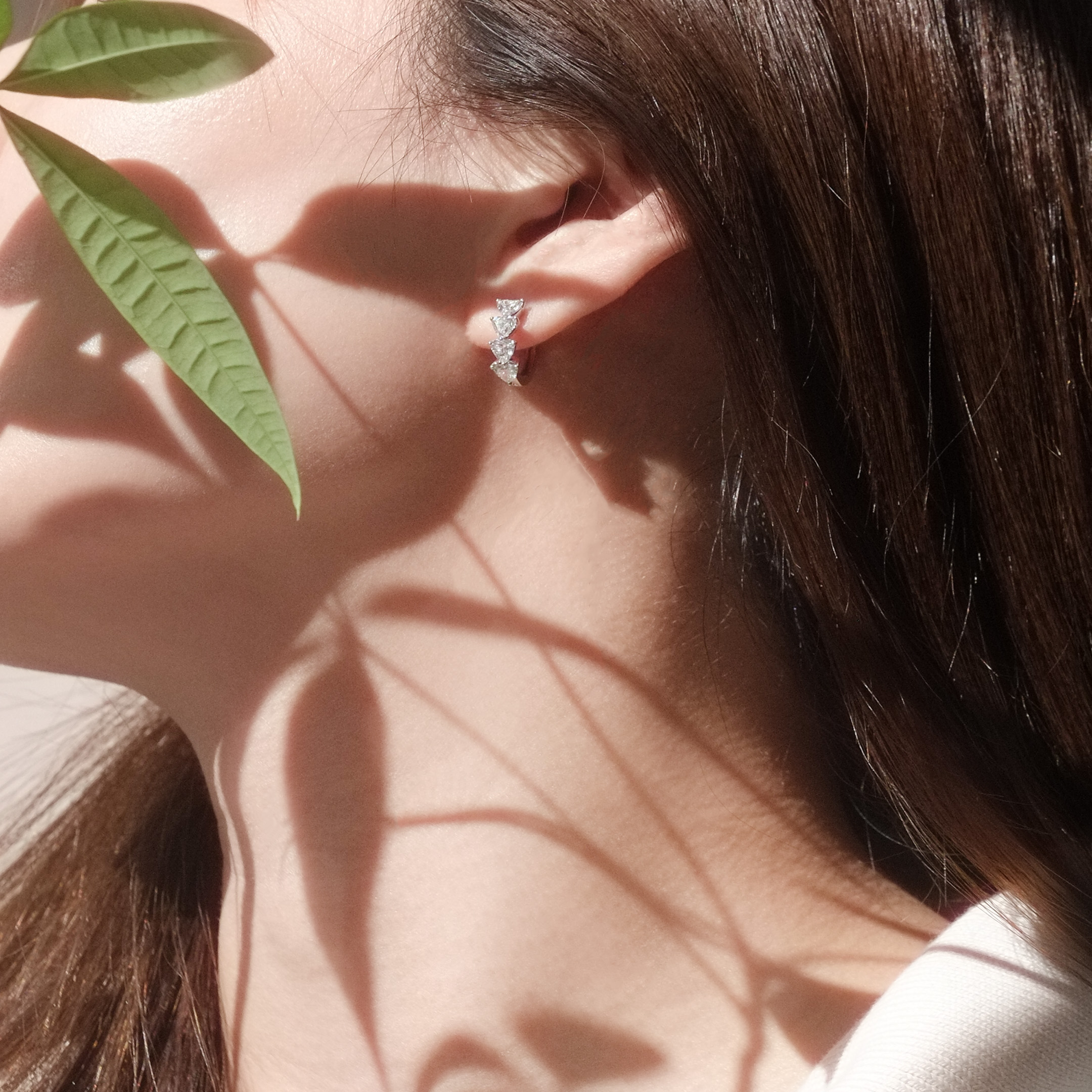 Model wearing 1.8ct heart shape diamond hoop earrings, capturing light sparkle.