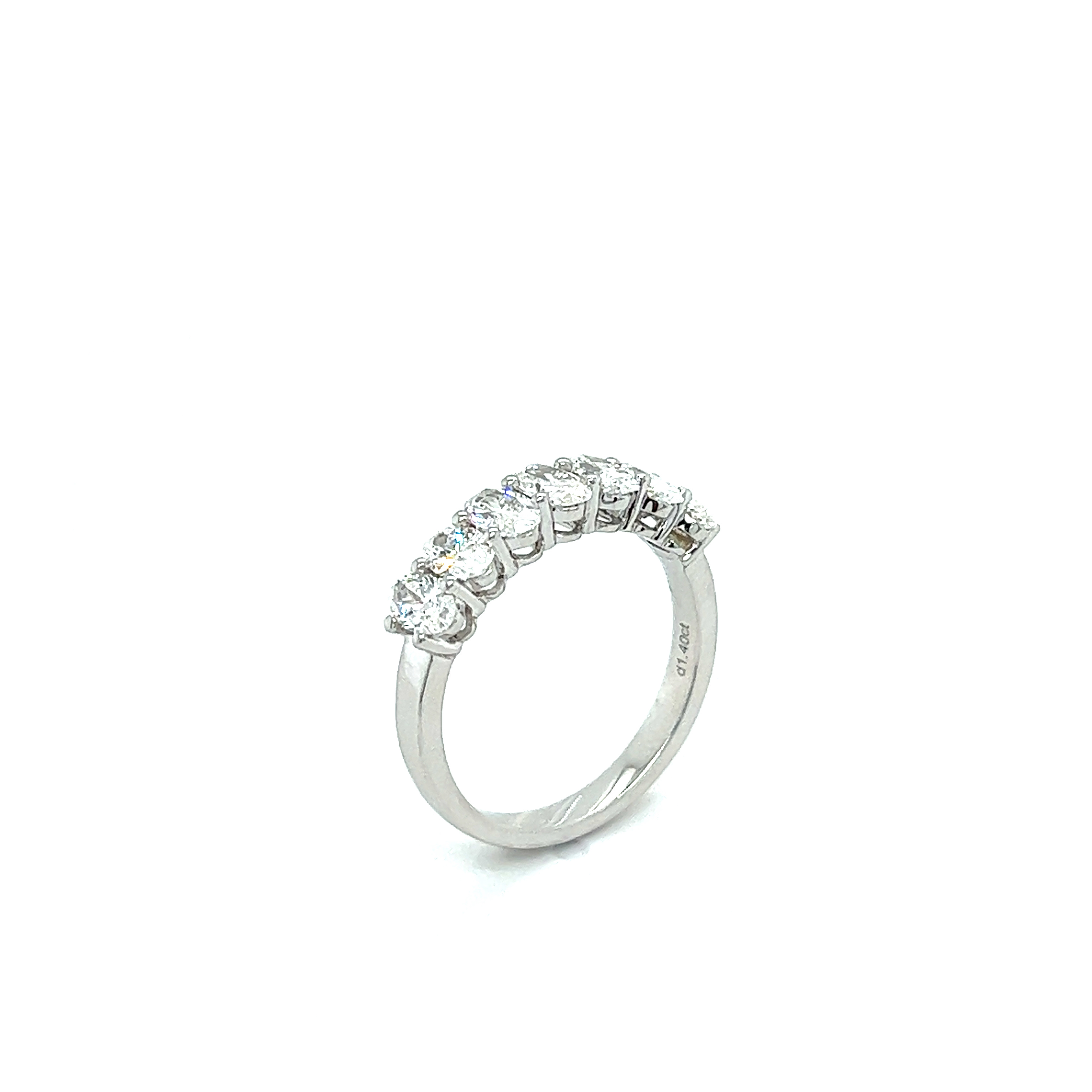 Side profile of luxury 7-stone diamond ring showing basket setting.

