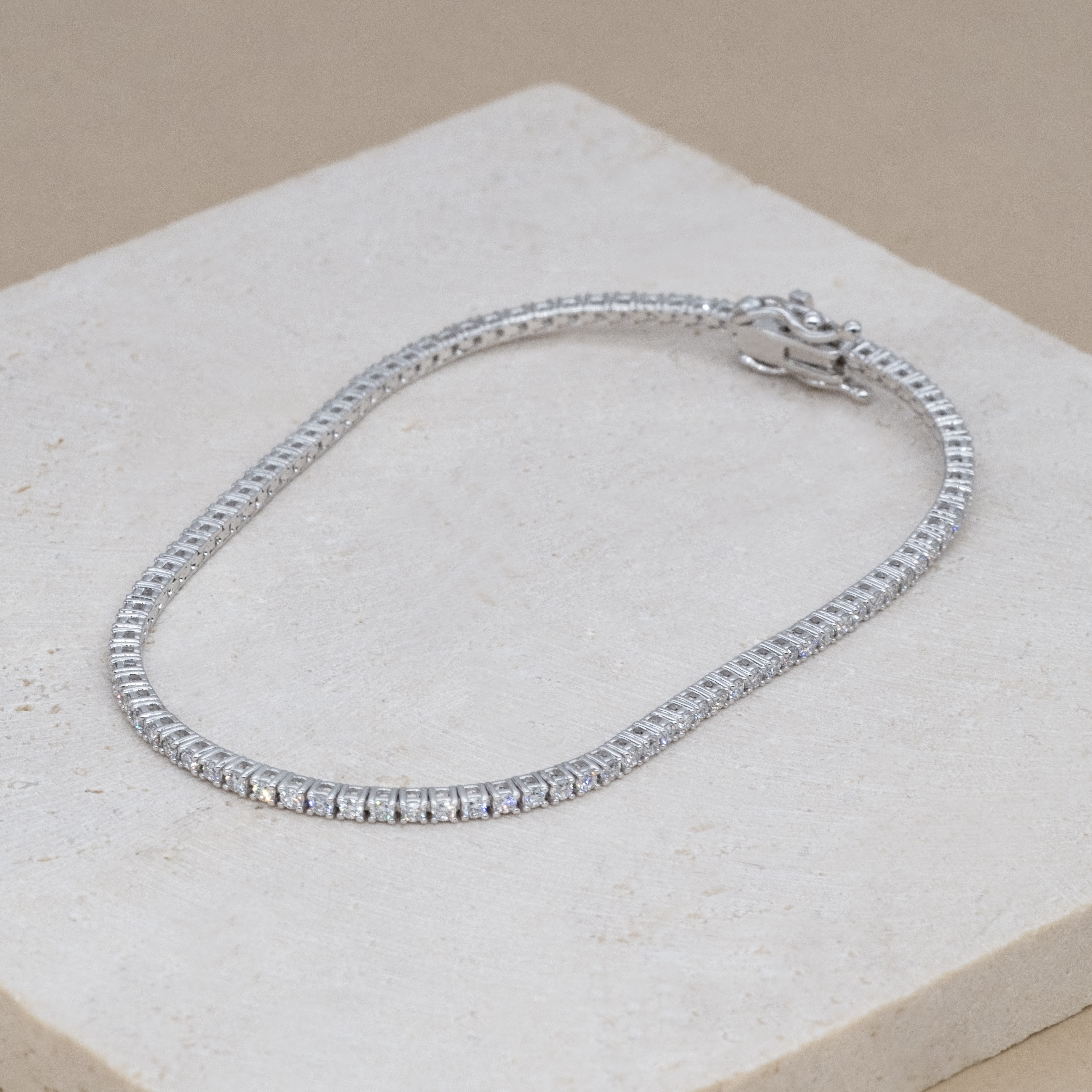 18K white gold micro tennis bracelets on stone texture background