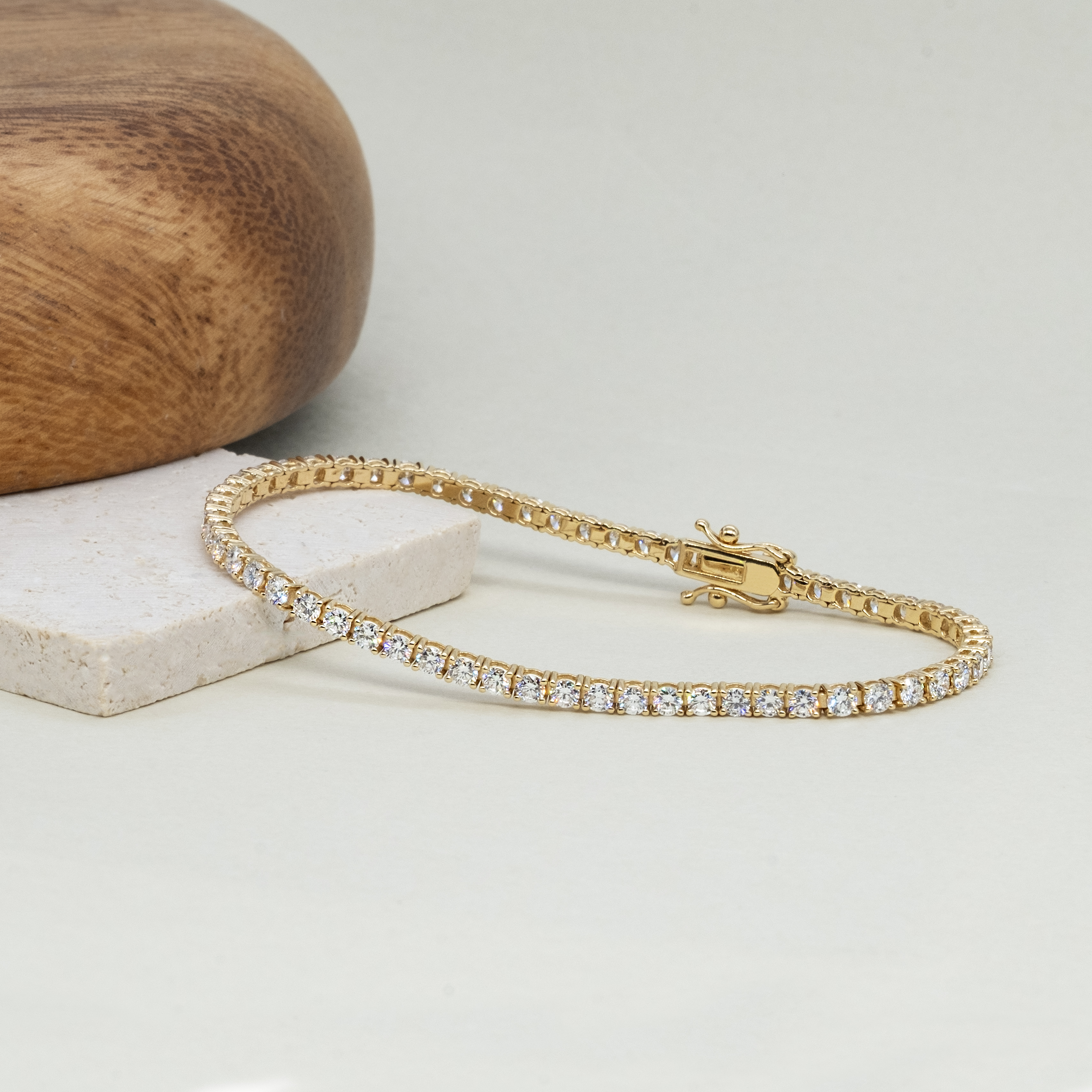 Close up of 2.8ct lab grown diamond tennis bracelet showing 2.3mm four prong setting 18k yellow gold