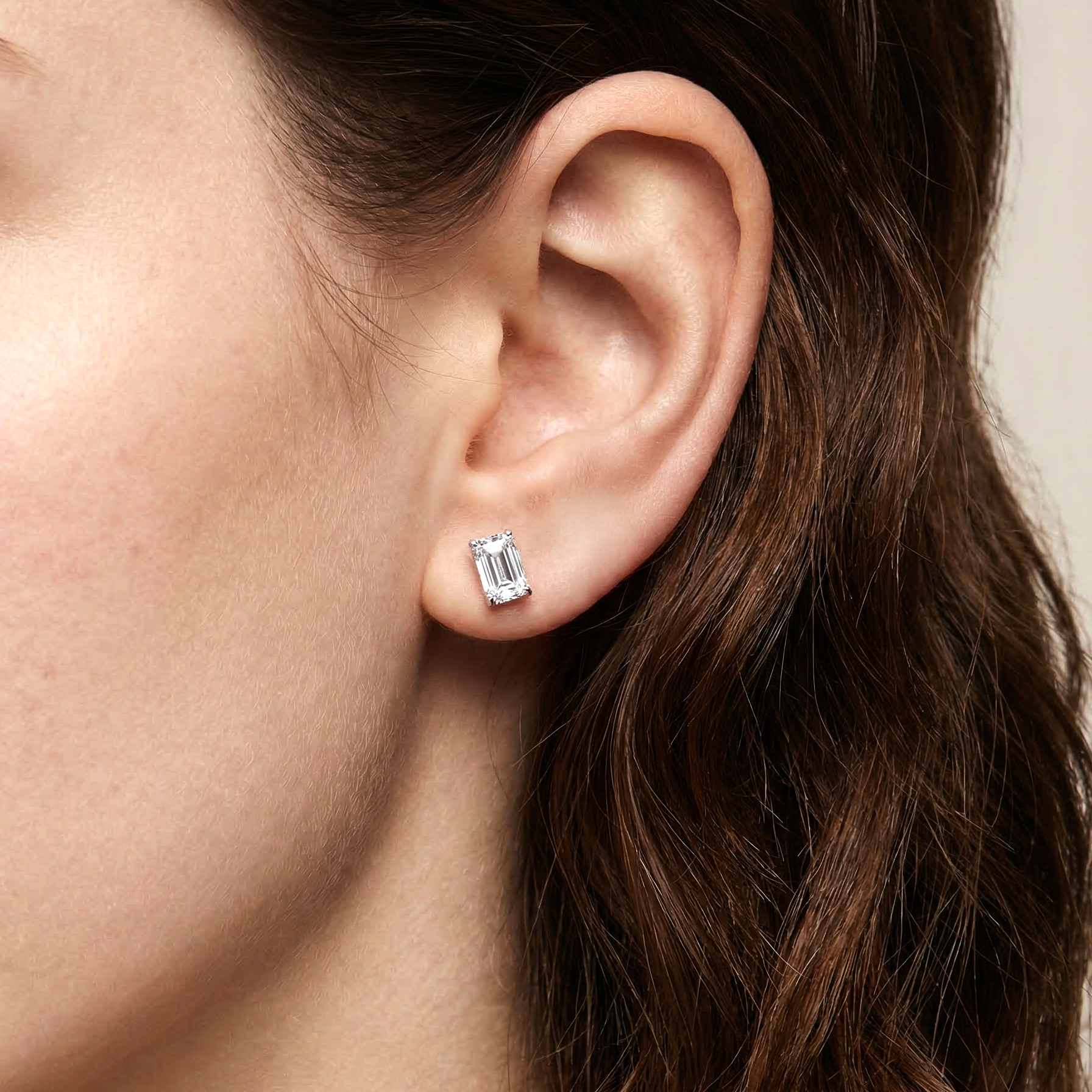 模特兒佩戴單邊 1 克拉祖母綠形培育鑽石耳環的實穿近拍。修長俐落的長方形輪廓（Emerald Cut）完美貼合耳垂，展現出低調奢華、不盲從潮流的老錢風 (Old Money) 氣質。1 克拉的清透光澤在耳畔散發著優雅而深邃的魅力。