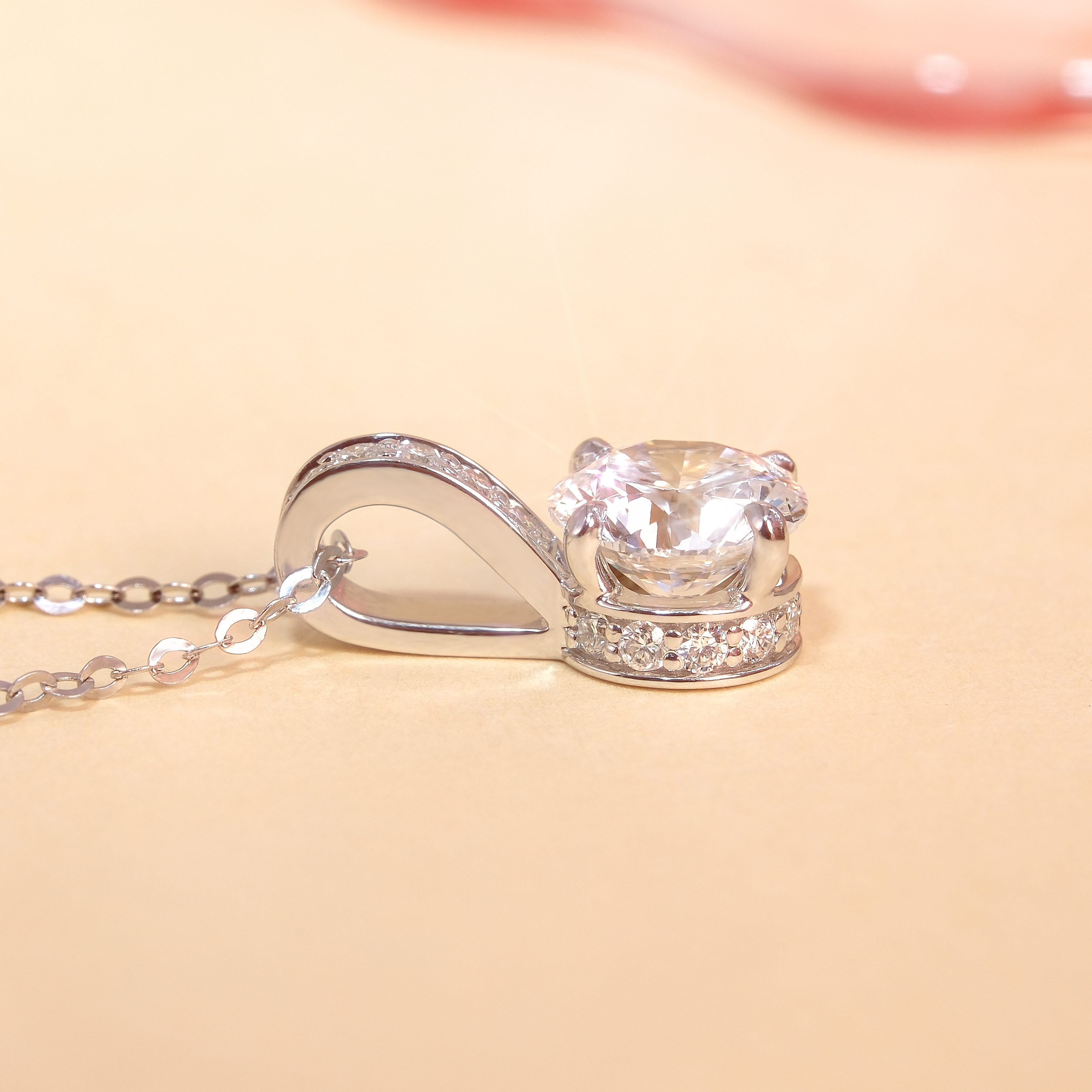 DIABOND 1 克拉培育鑽石吊墜的側面平放特寫。清晰展示了極致講究的鑲嵌工藝:主石下方環繞著精緻的隱藏光環 (Hidden Halo),而吊墜的 V 型扣環處則採用了密釘鑲嵌 (Pave Setting) 點綴天然碎鑽。18K 白金的流暢線條讓 1 克拉 D 色主鑽的厚度與火彩一覽無遺。