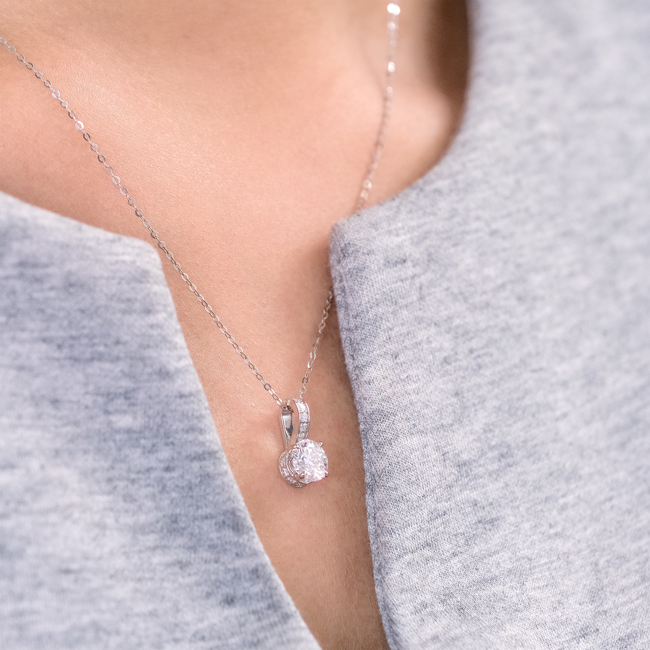 模特兒佩戴 1 克拉培育鑽石吊墜的閃耀效果近拍。得益於隱藏光環 (Hidden Halo) 的透光設計,主石能吸收更多光線,散發出極具爆發力的純淨火彩。無論是作為送給摯愛的紀念禮物,或是犒賞自己的奢華單品,皆是完美之選。