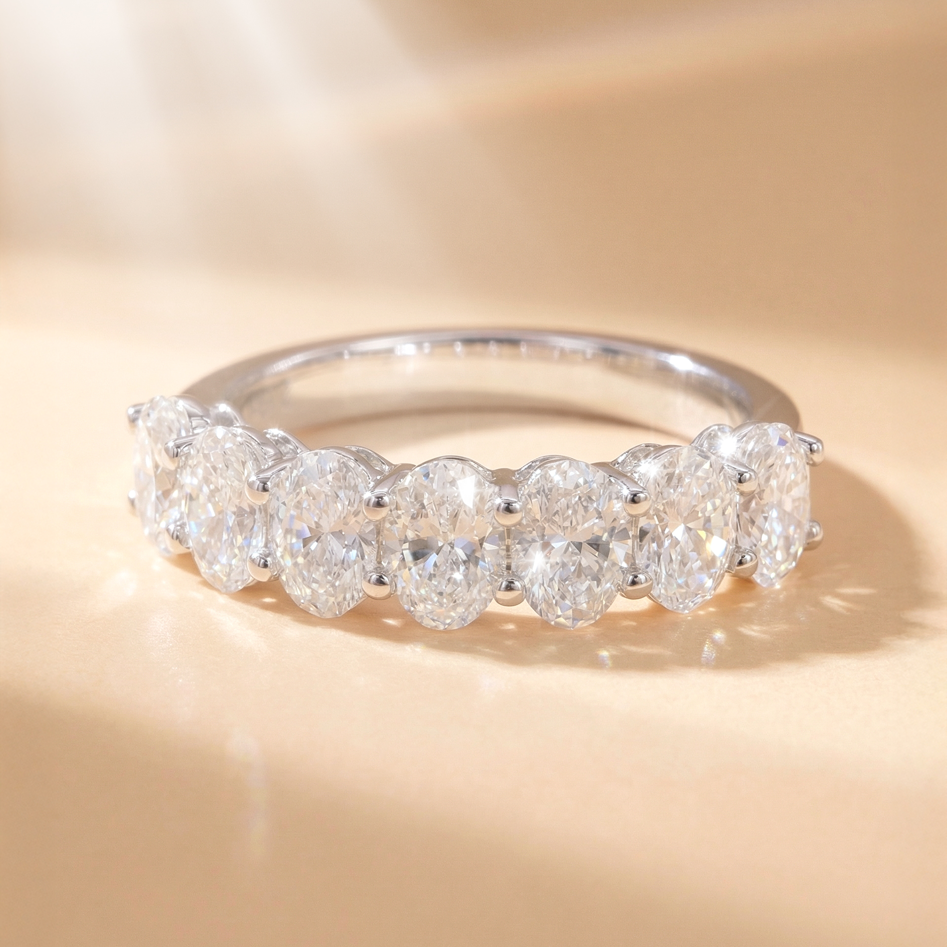 DIABOND 2.1 克拉七石橢圓形培育鑽石排戒平放展示。採用 18K 白金材質，7 顆重約 0.3 克拉、高等級 DEF/VVS 的橢圓形切割 (Oval Cut) 鑽石緊密並排鑲嵌。在光影下展現出極致閃耀的火彩與連綿不斷的璀璨光環。