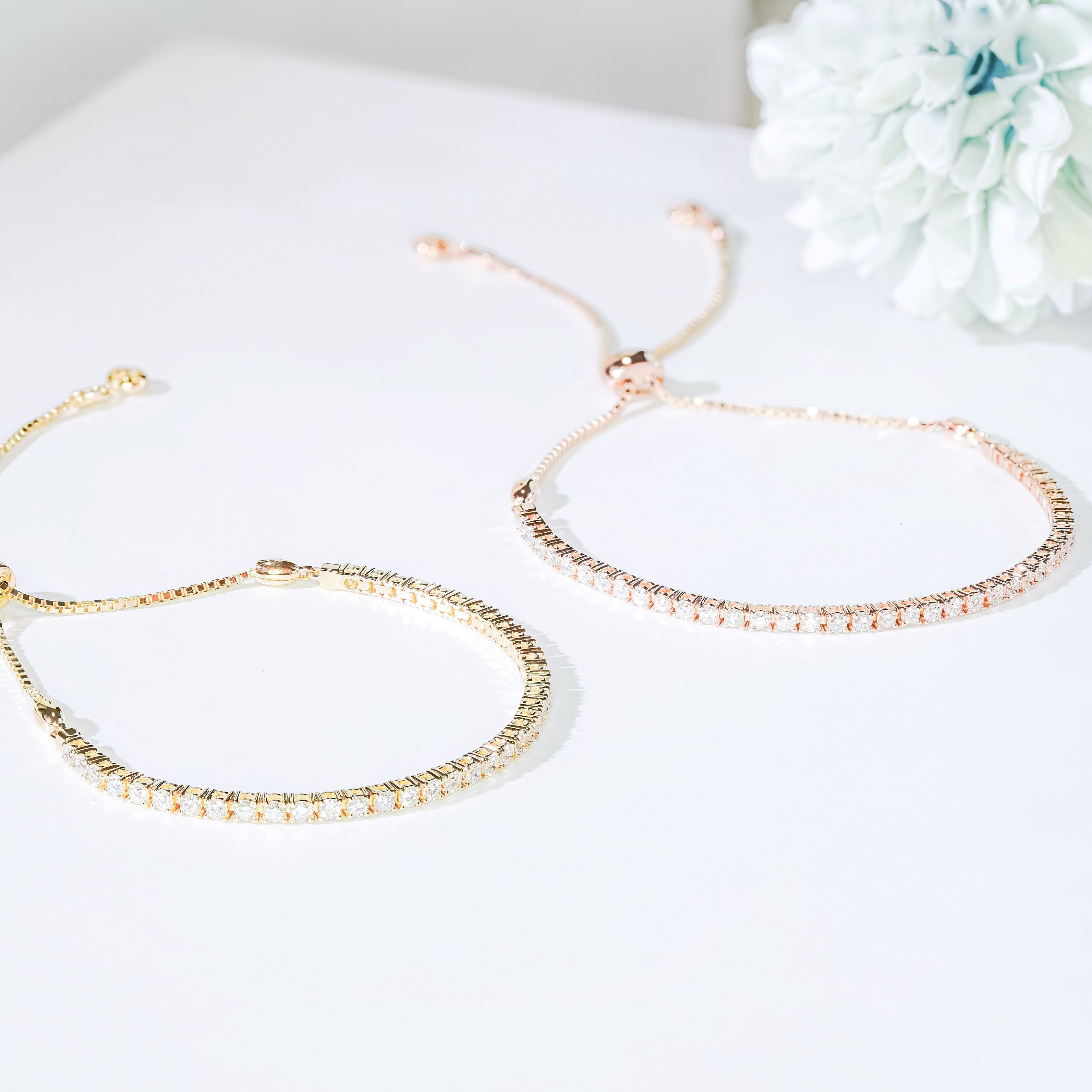 Adjustable half tennis lab grown diamond bracelets in yellow and rose gold with bolo slider clasp.