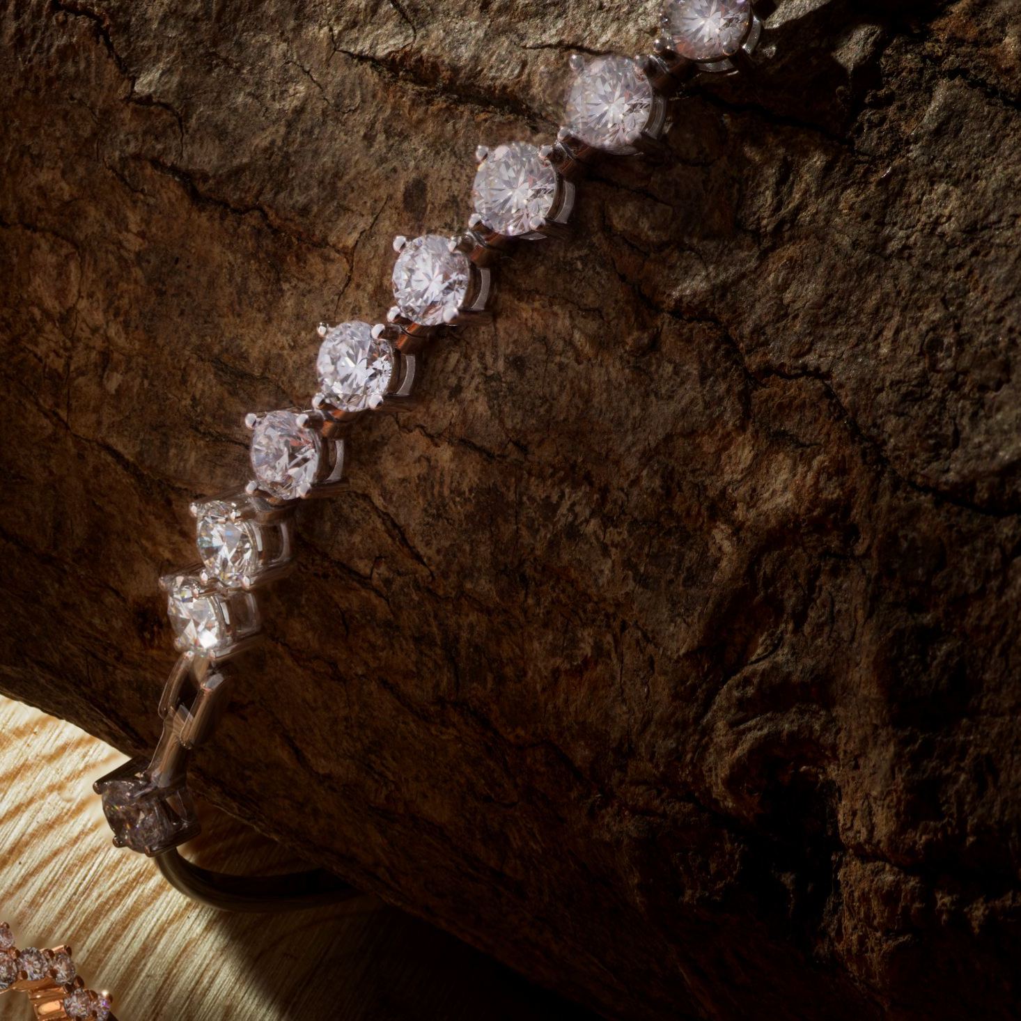 close up of 4-prong set diamonds on 18K gold station bangle bracelet