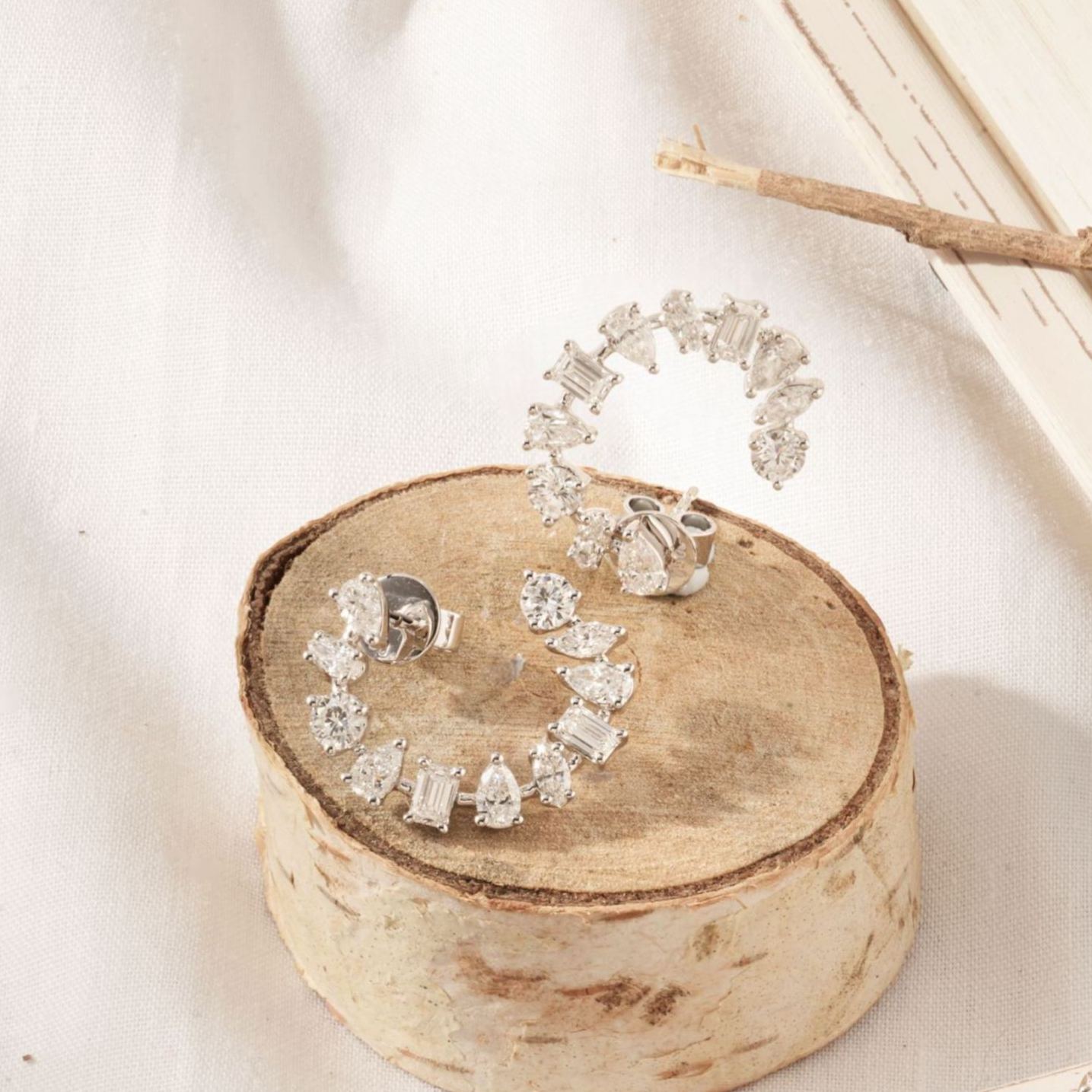 Close up of 18K white gold open hoop earrings with multi-shape lab grown diamonds.