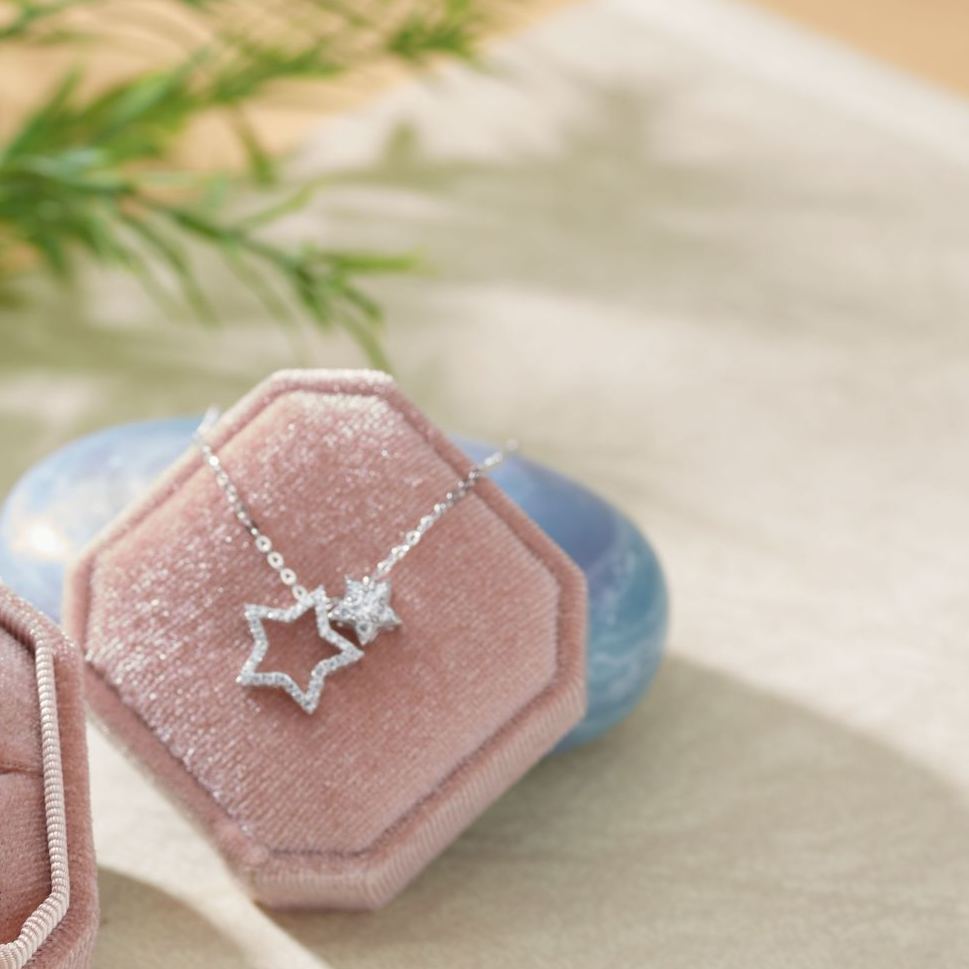 Convertible diamond pendant separated into small star and open star frame.