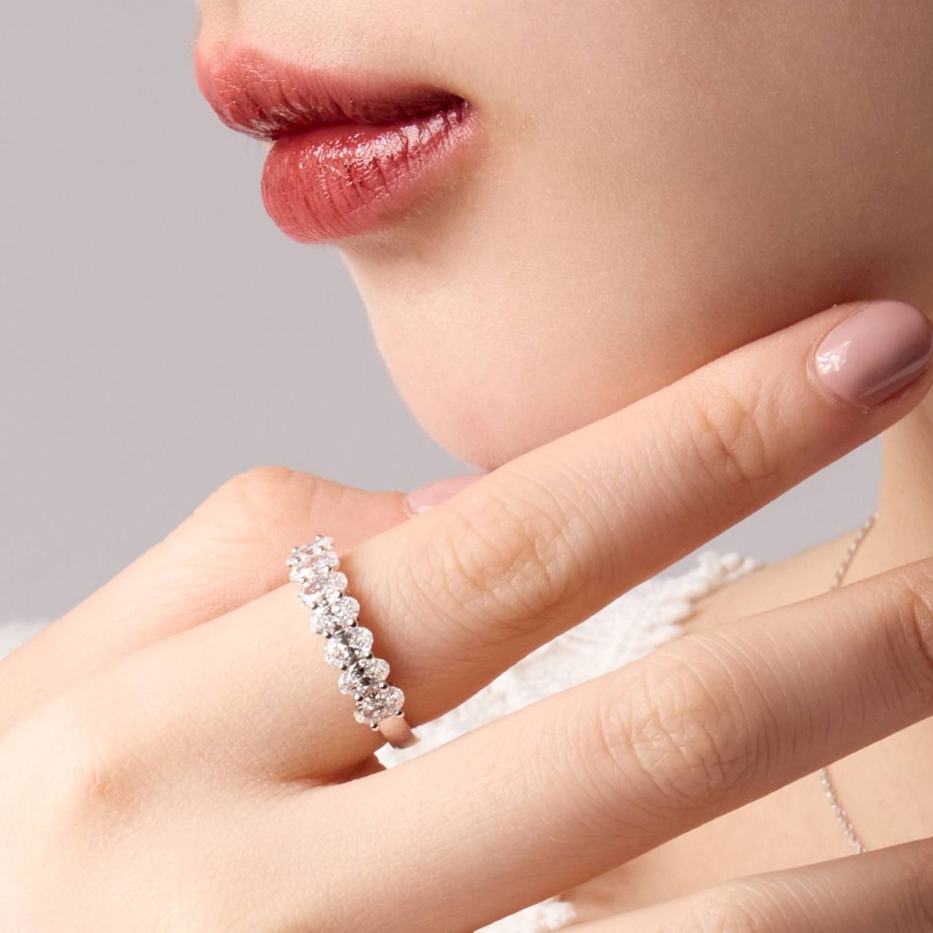 Woman wearing 1.3ct oval diamond anniversary band on ring finger.