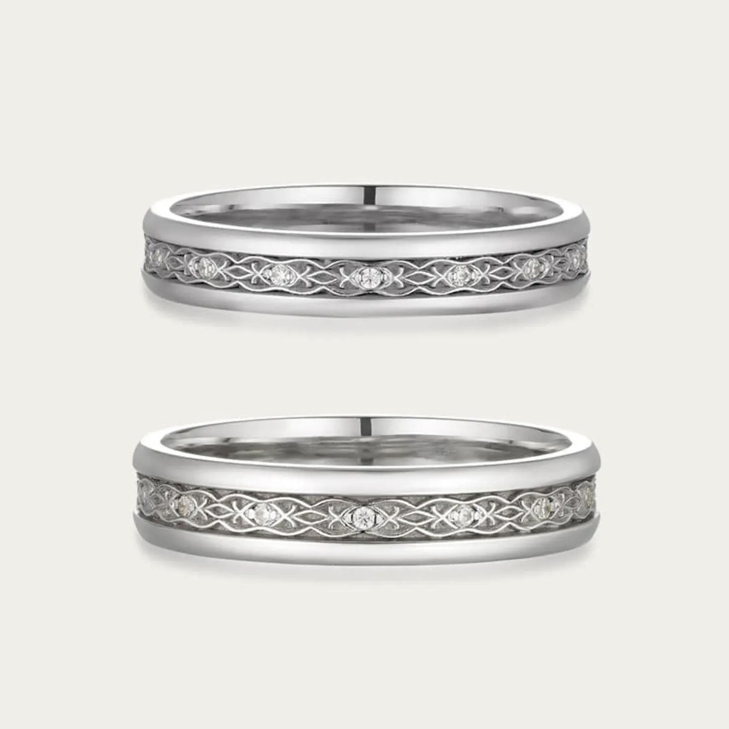 DIABOND 銀白色交織鏤空天然鑽石結婚對戒平放展示。戒指中央雕刻著精緻的無限編織紋理 (Infinity Knot)，線條鏤空交錯，象徵兩人命運緊密相連。上下邊緣飾以平滑金屬圈，增添古典層次感。