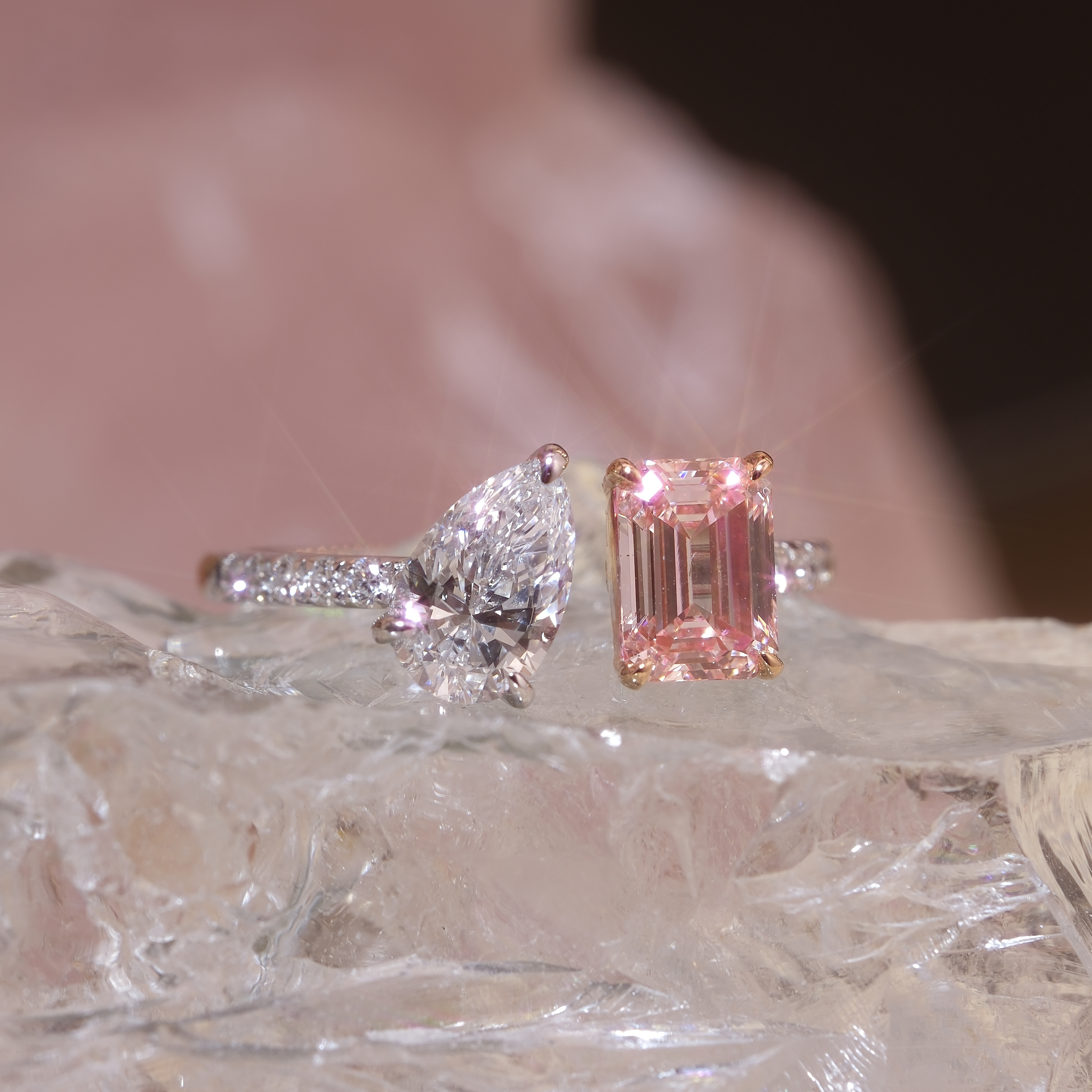 DIABOND Toi Et Moi 雙主石戒指平放展示。左側為 0.72ct 梨形白鑽配 18K 白金排鑽戒臂，右側為 1.02ct 祖母綠形培育粉鑽配 18K 玫瑰金四爪鑲嵌。兩枚主石並置，展示雙色金設計的高訂對比美學。
