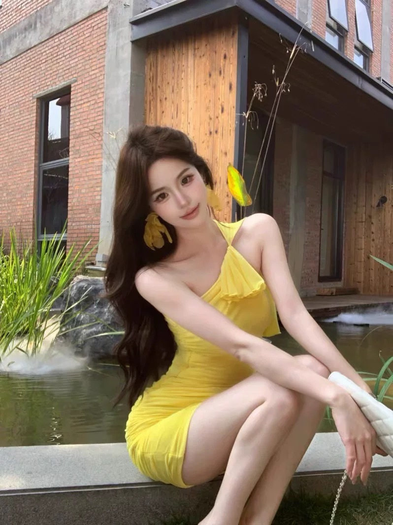 2026年春夏韩版小众性感黄色挂脖斜领连衣裙女千金感褶皱包臀裙