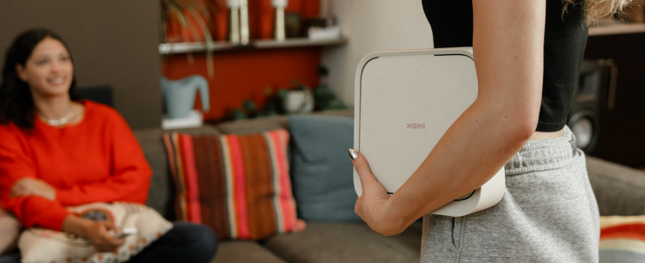 User holding the Elfin Flip projector with one hand, highlighting its portability