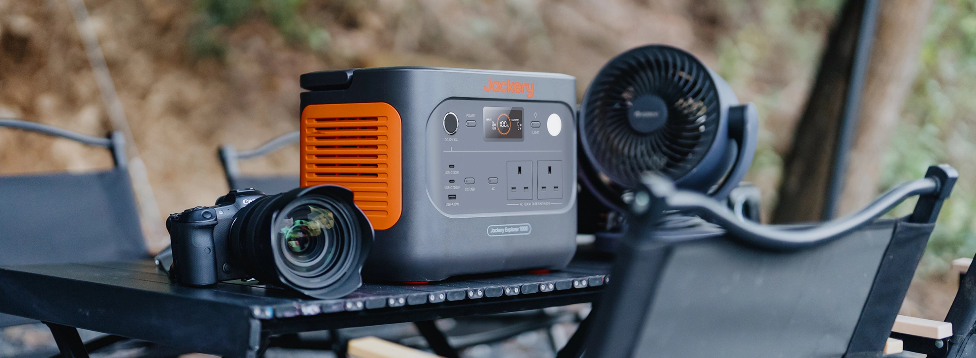 On the camping table, Jackery's 1000 v2 portable power station is providing power to the camera and fan.