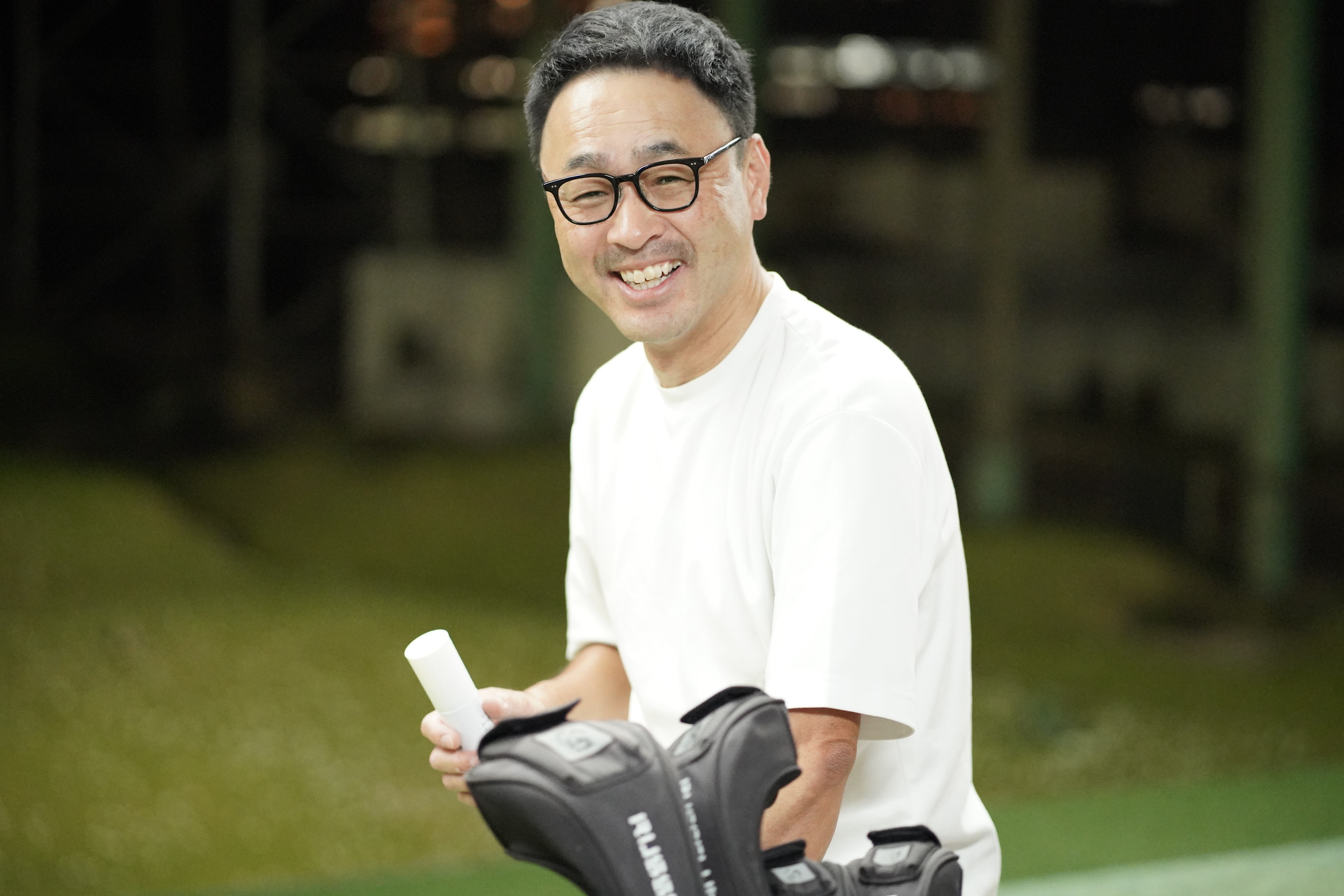ゴルフクラブを前に笑顔を見せる西田様