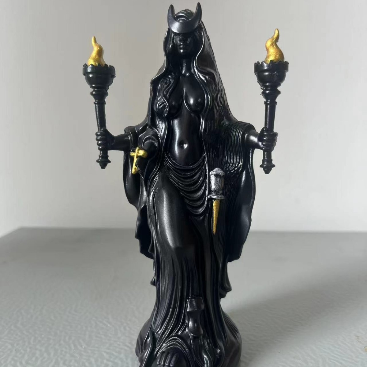 A sculpture of a dark goddess holding a torch, a resin ornament ✨ that brings a sense of healing and relaxation.