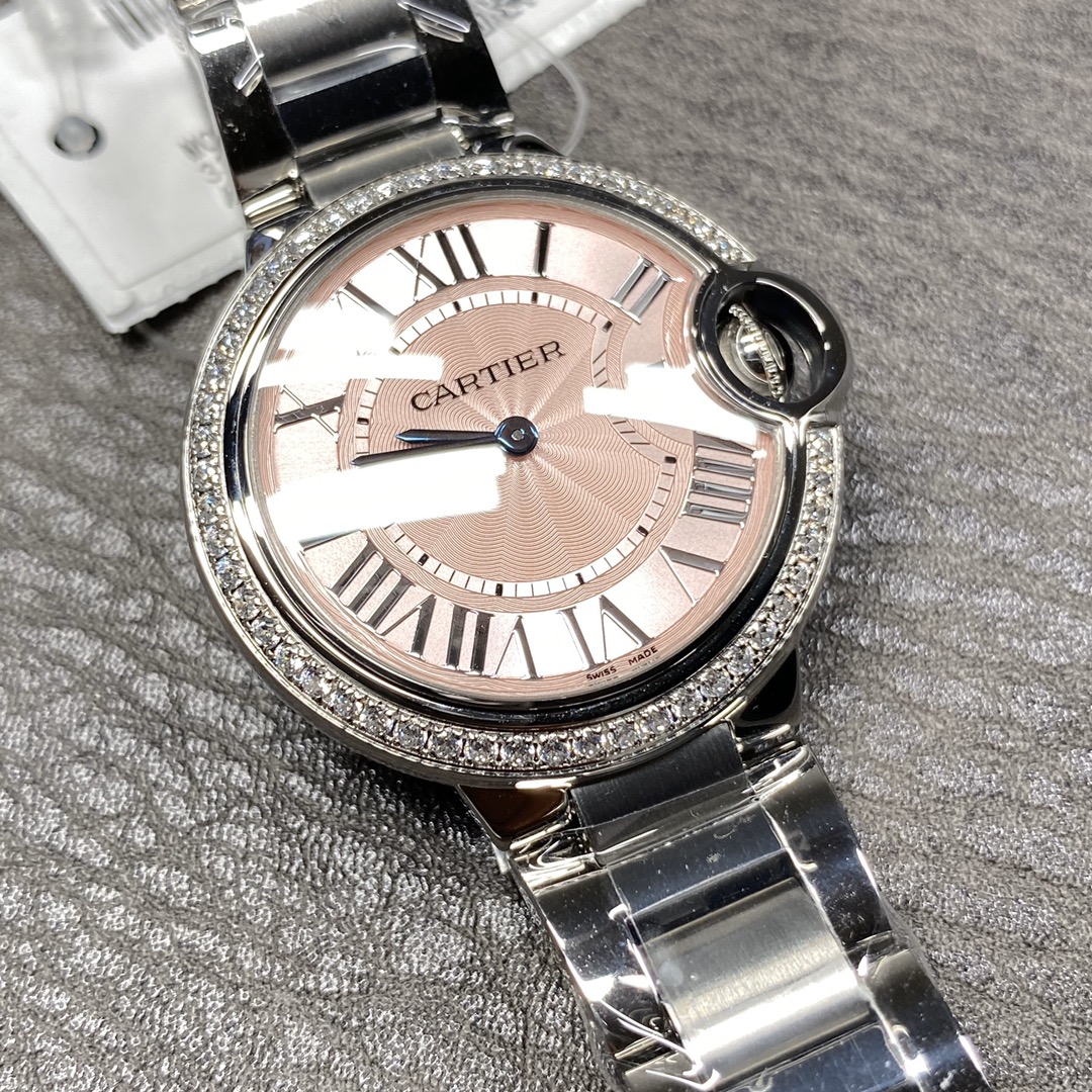 Cartier Ballon Bleu Collection! Model WE9003Z3, ladies' watch with a 33mm case diameter. The pink Ballon Bleu has always been a classic, and this version features a steel bracelet with diamond accents.