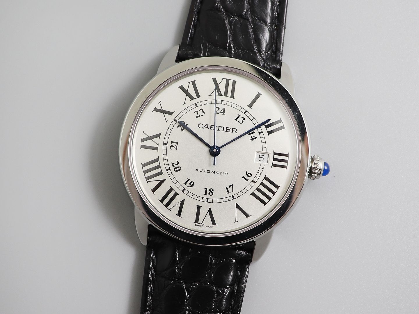 The Cartier Ronde de Cartier London Collection W6701010, upgraded to Version V2, features Cartier's highly recognisable Roman numeral hour markers, sword-shaped blued steel hands, and a deep blue spinel crown. Its simple three-hand design with date functi