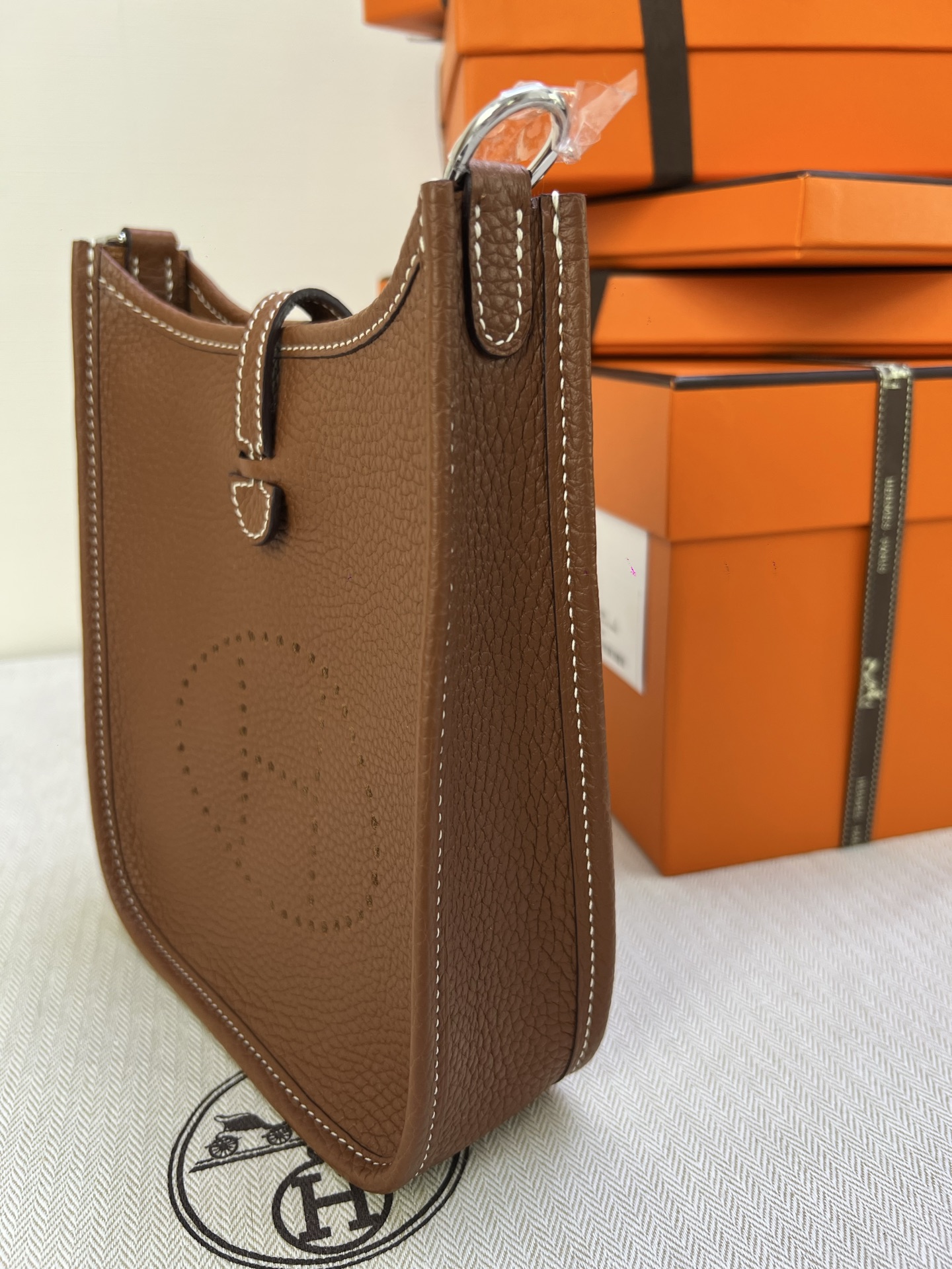 Hermès Model: Mini Evelyne Color: Golden Brown with Silver Buckle Dimensions: 16cm x 18cm x 5cm