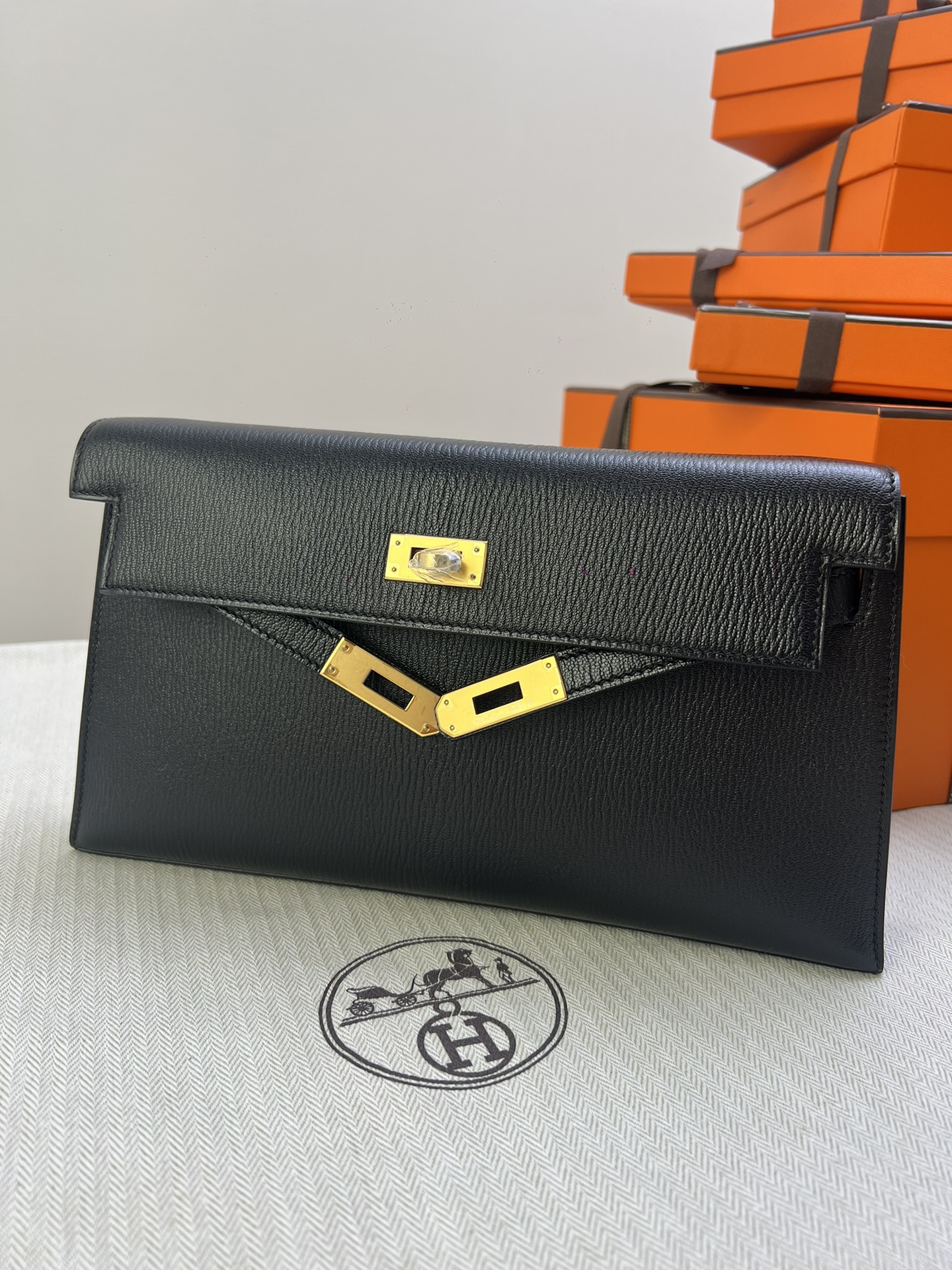 Hermès Model: Kelly Elan Color: Black with gold hardware Dimensions: 27.5cm x 15cm x 5cm
