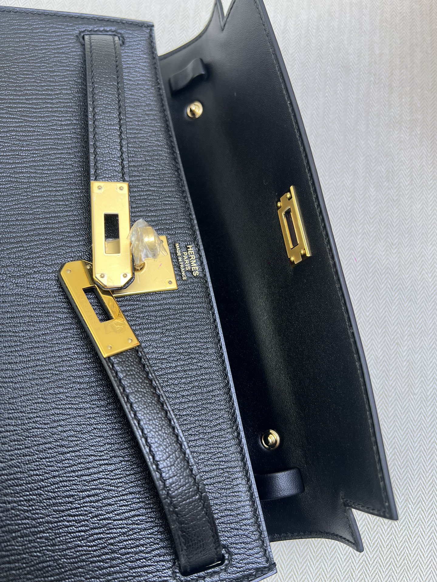 Hermès Model: Kelly Elan Color: Black with gold hardware Dimensions: 27.5cm x 15cm x 5cm