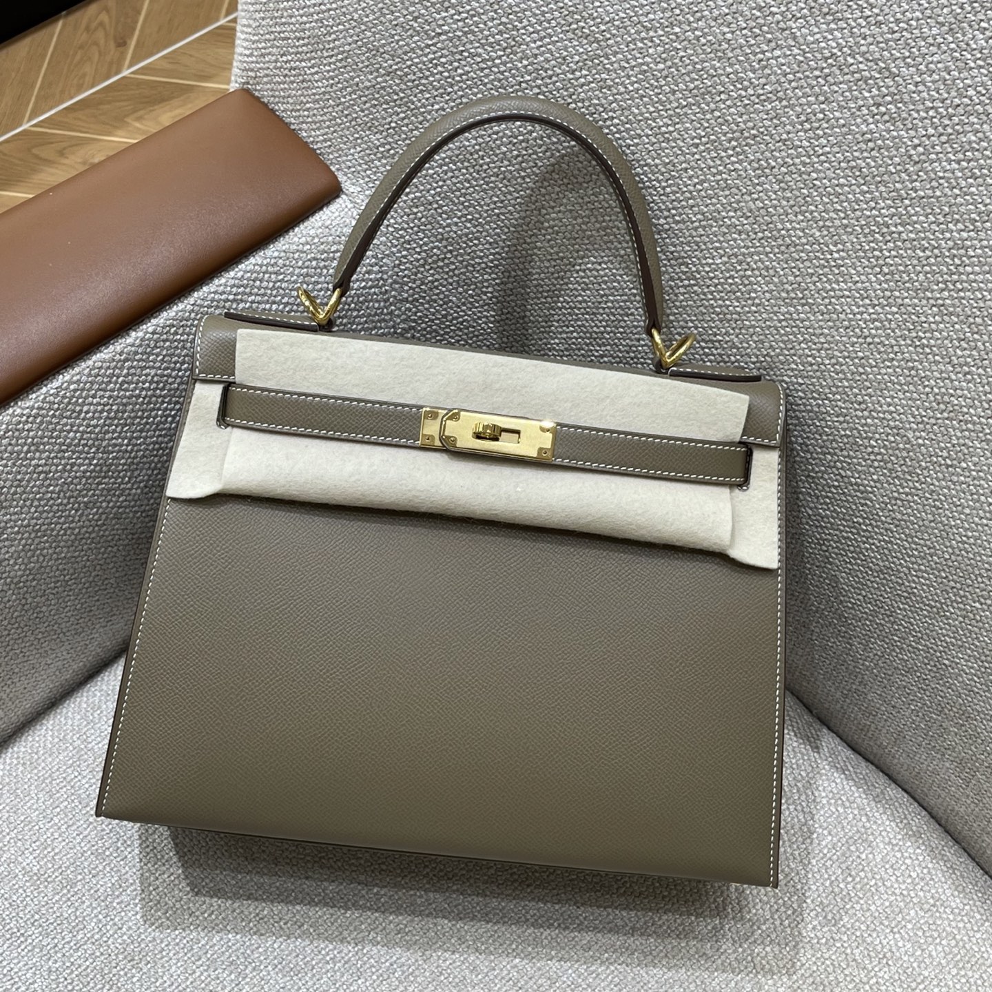 Hermès Model: Kelly 28 (Exterior Stitching) Color: Elephant Gray with Gold Hardware Dimensions: 28cm x 22cm x 10cm (including handles)