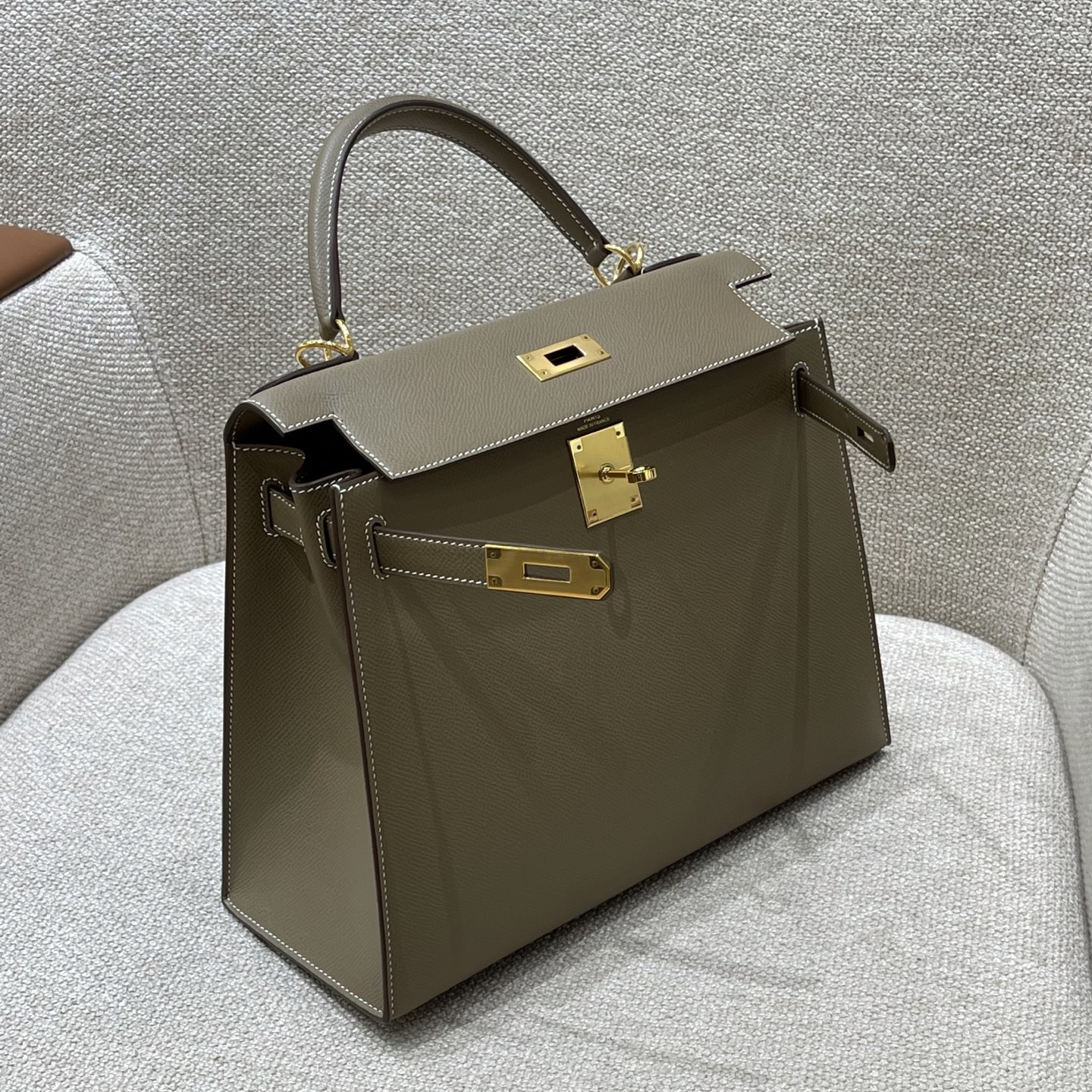 Hermès Model: Kelly 28 (Exterior Stitching) Color: Elephant Gray with Gold Hardware Dimensions: 28cm x 22cm x 10cm (including handles)