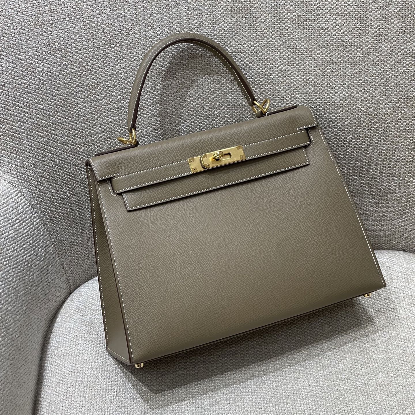 Hermès Model: Kelly 28 (Exterior Stitching) Color: Elephant Gray with Gold Hardware Dimensions: 28cm x 22cm x 10cm (including handles)