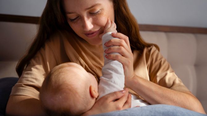 Photo of a mum holding her baby before feeding, representing breast pumps and breast pump flange