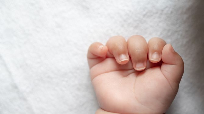 Photo of a baby's hand and nails, showing that you need a baby nail care trimmer set to trim them properly