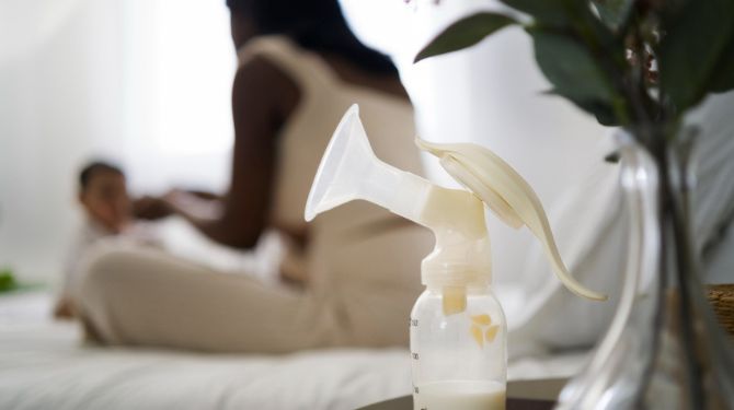 Photo of a mother and her child, with a manual breast pump in the foreground