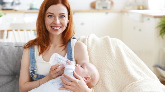 A woman feeding her baby after using a silicone breast pump