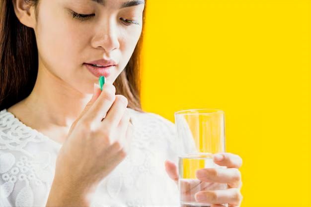 lady swallowing pill yellow