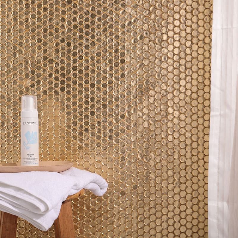 薄い白いカーテン越しに見える金色ガラス円形モザイクタイルの壁面