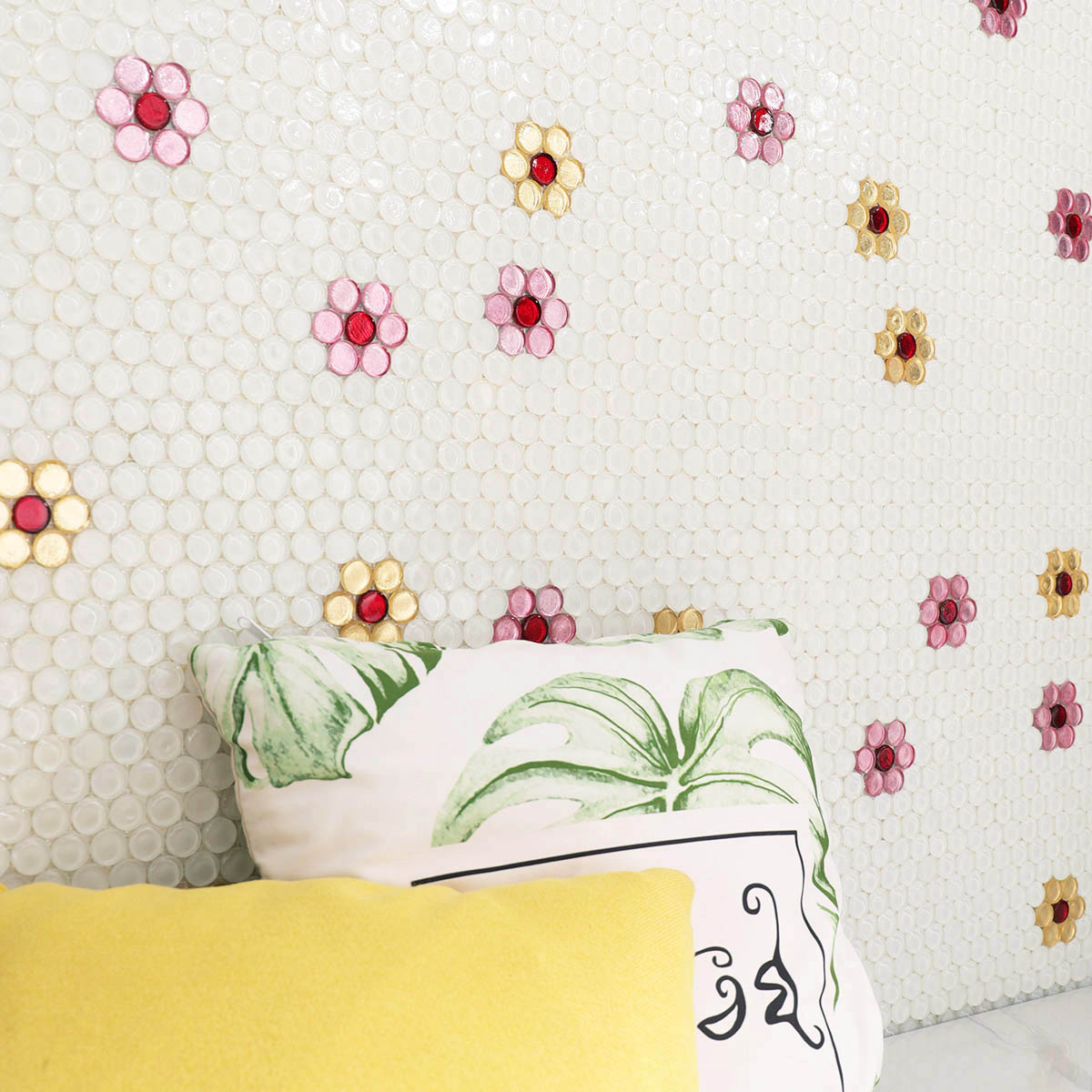 ソファクッション越しに見える、散りばめられた花柄丸形ガラスタイルの壁面