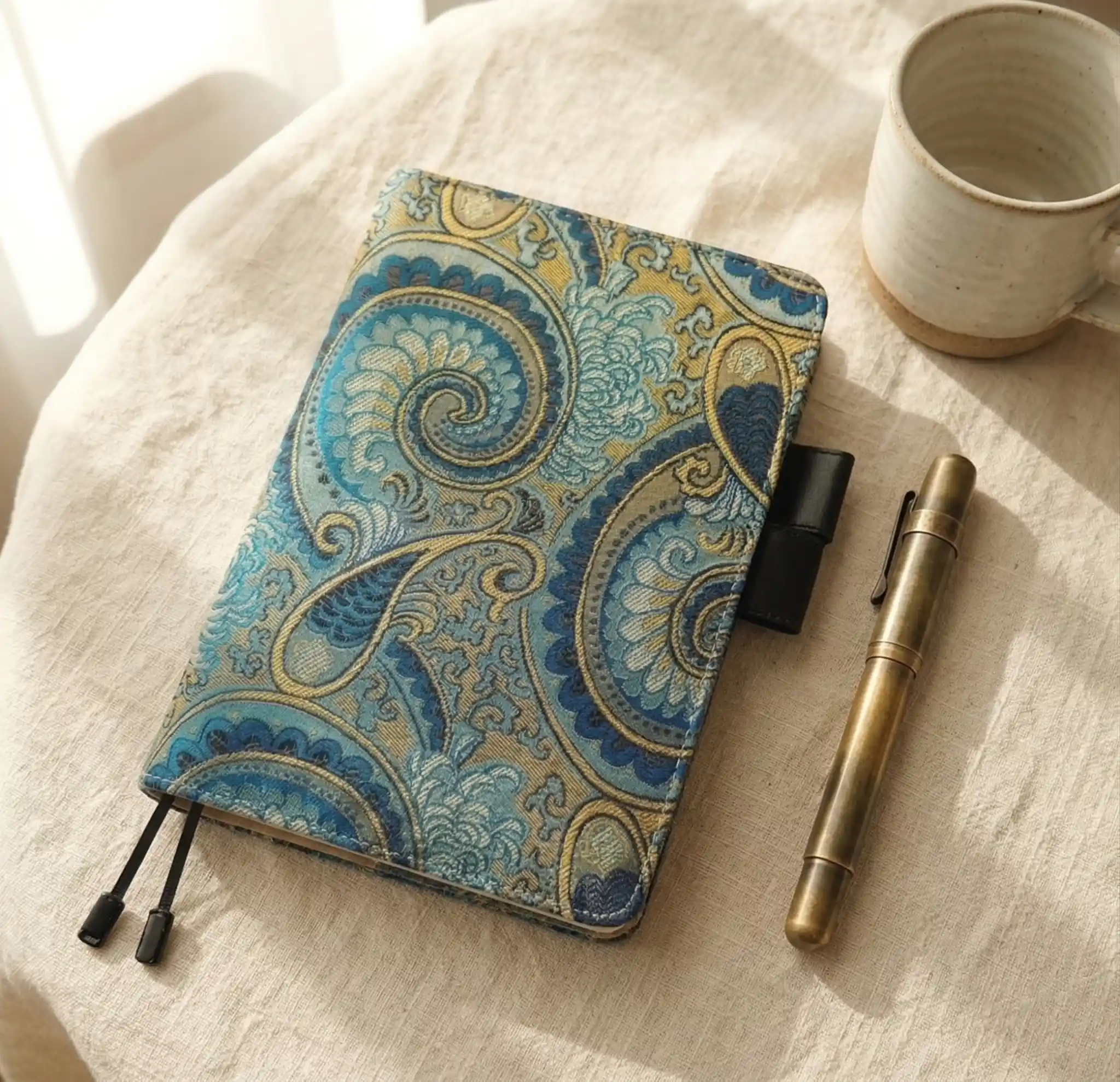 Aesthetic desk setup with an A5 organizer cover styled for Hobonichi Cousin, paired with a brass pen and mug.