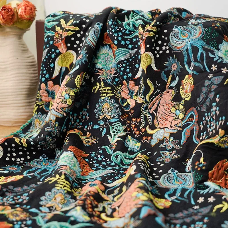 Black fabric with colorful embroidered rabbit and floral pattern