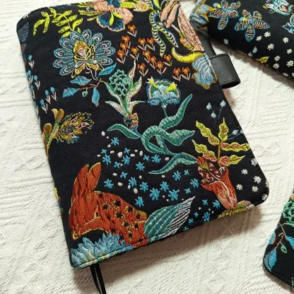 Close-up front view of black floral and rabbit embroidered planner cover