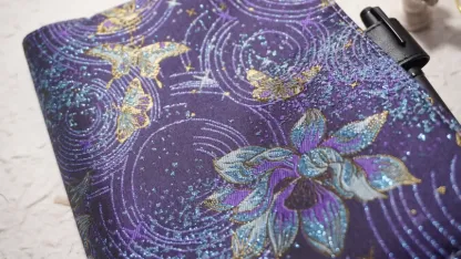 Close-up of purple celestial orchid embroidery and black pen loop on planner cover