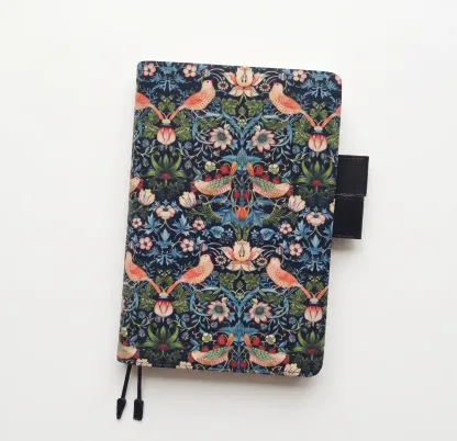 Clean product photography of a William Morris pattern planner cover compatible with Hobonichi A5 on a white background.