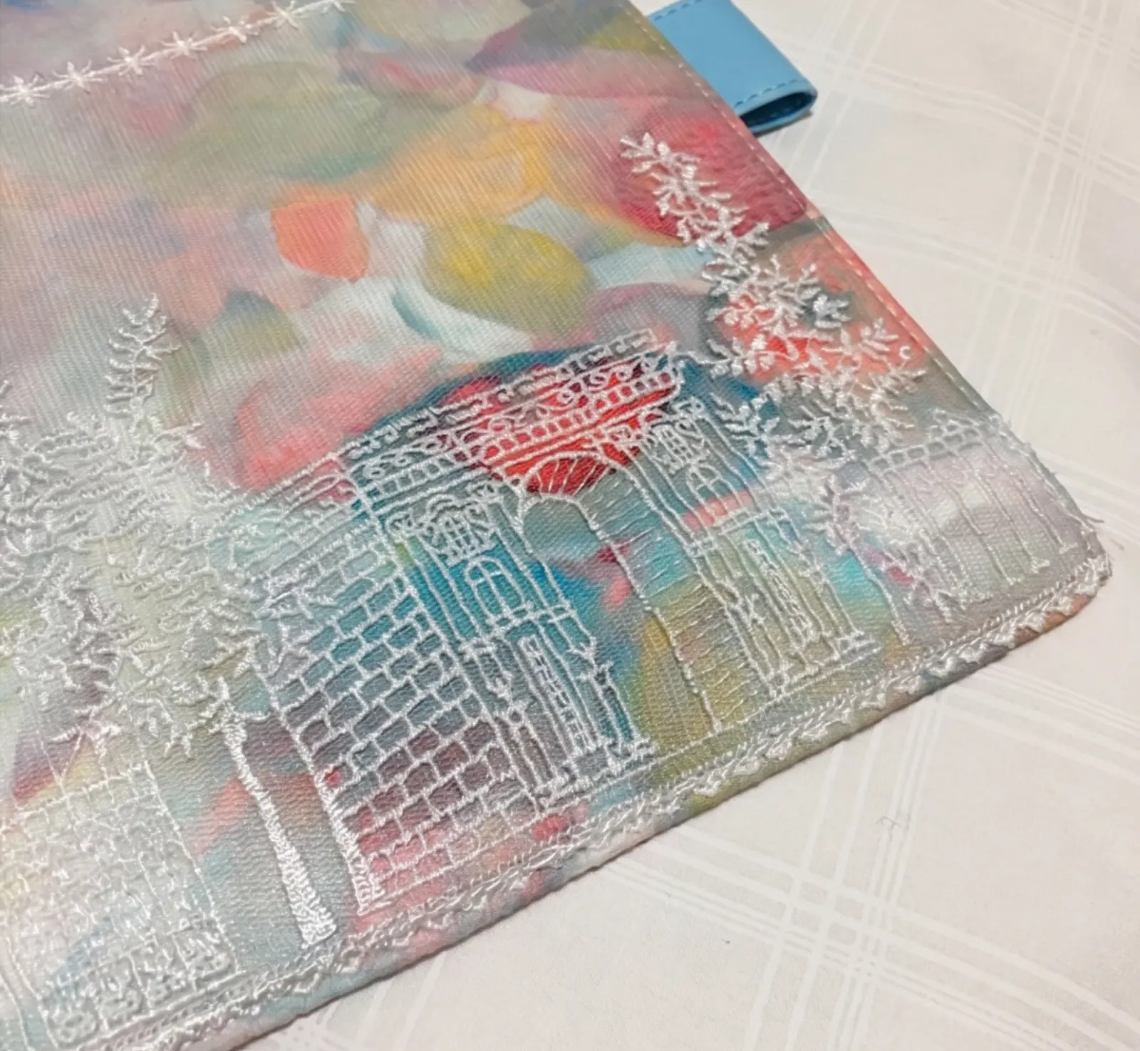 Close-up of pastel floral castle embroidery on fabric planner cover