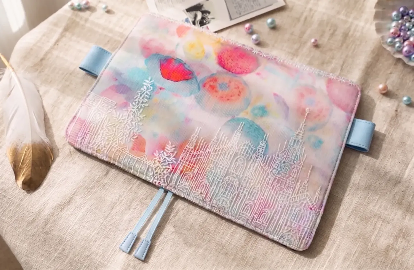 Pastel floral castle embroidered planner cover styled on a desk