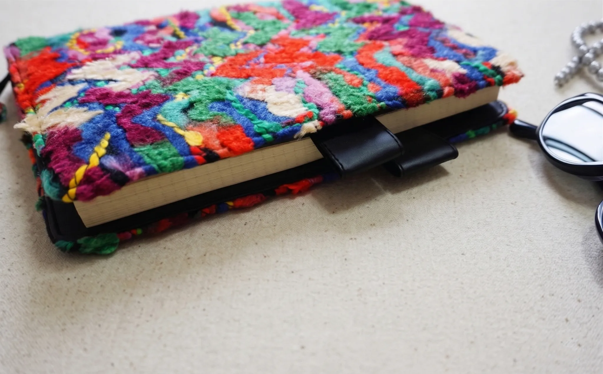 Side view of thick textured fabric planner cover showing Hobonichi notebook inside and double pen loops.