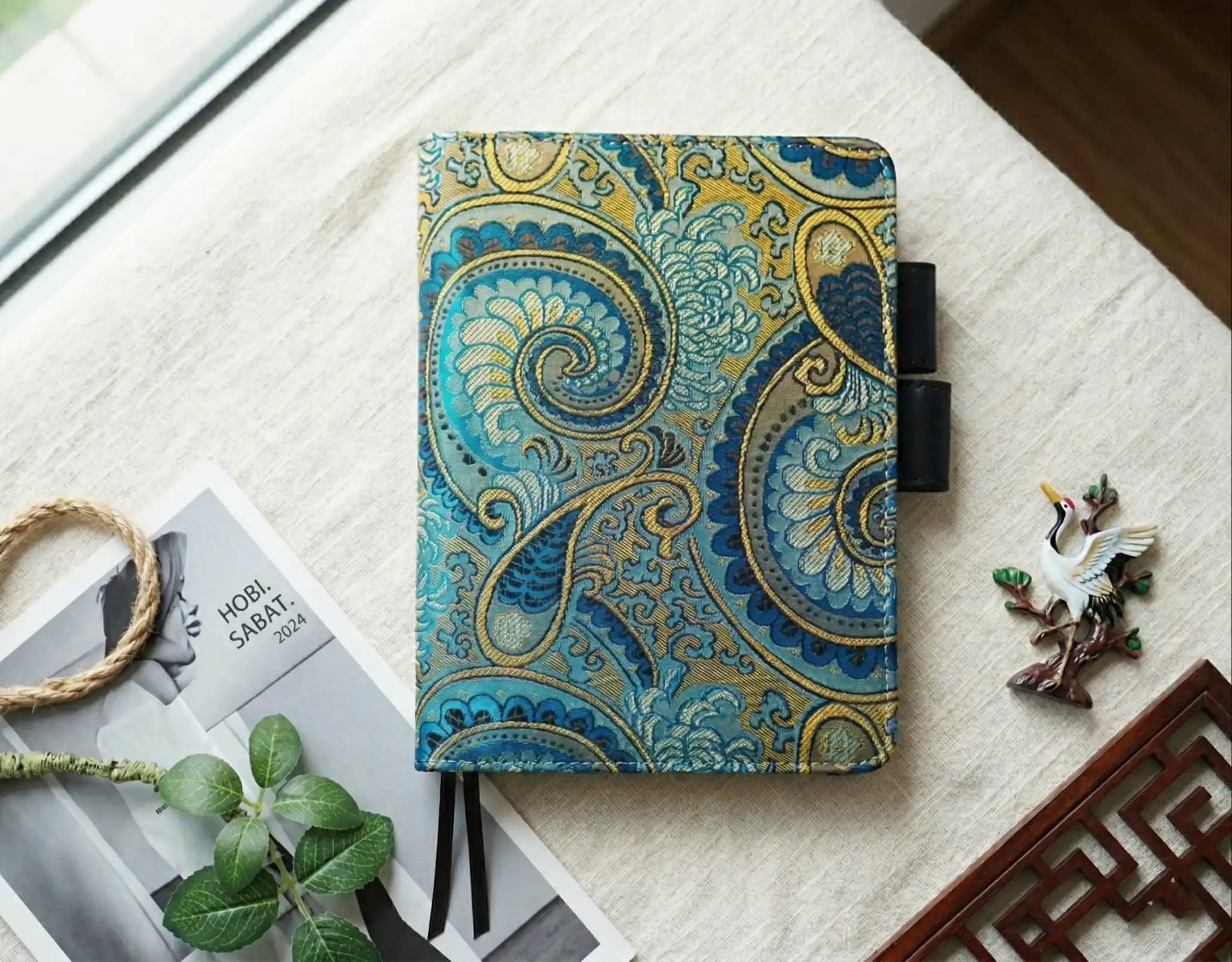 Luxury paisley brocade planner cover styled for Hobonichi Techo A6, pictured in an artisanal workspace.