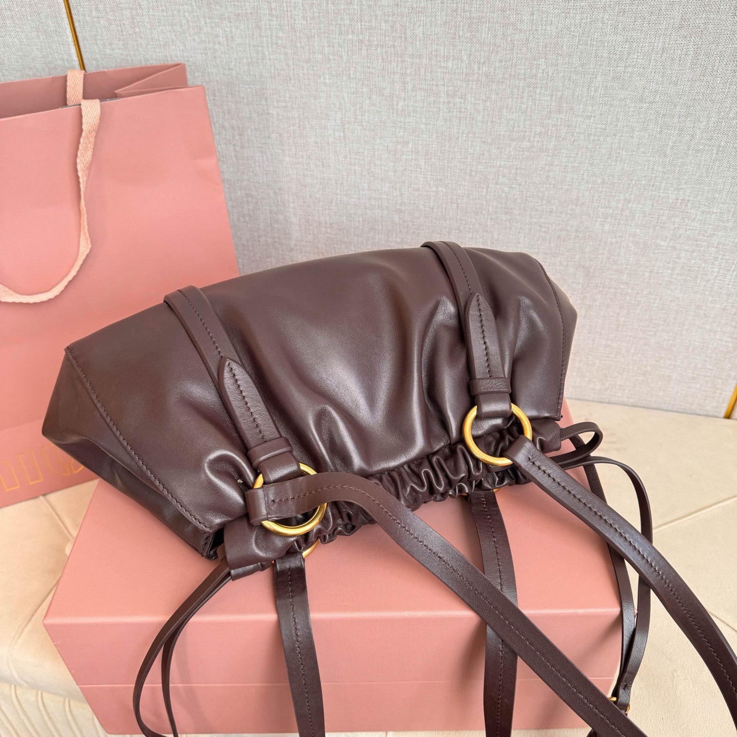 MIU中古腋下饺子包，全新植柔羊皮满满复古怀旧风情，搭配钢质做旧金属五金配件，质感高级典雅，袋口采用抽绳束口设计，细密的皱褶花边立体而俏皮，高级又不失慵懒随性，内搭全新条纹帆布里，配一个拉链隔层，独特的设计谁用谁好看