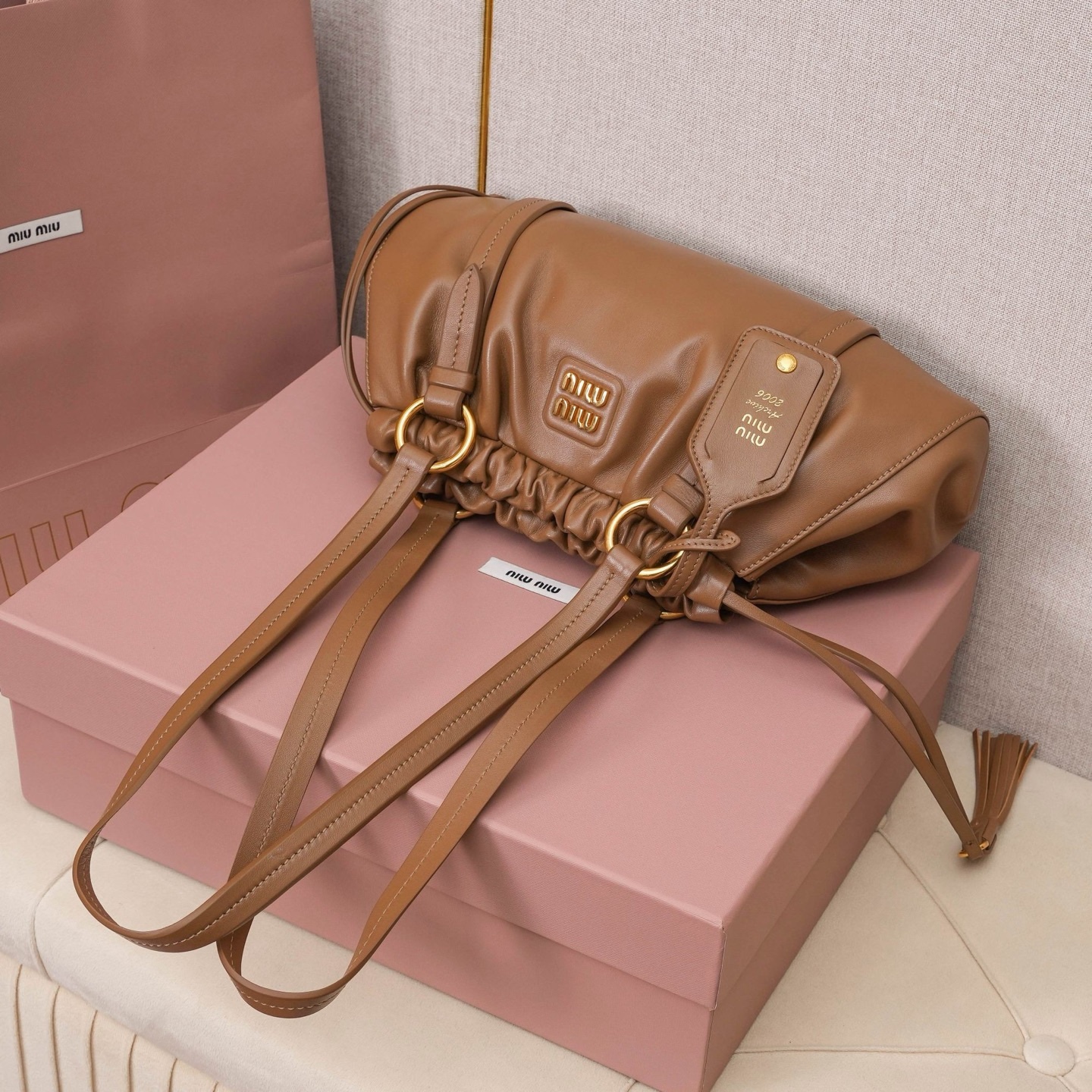 MIU中古腋下饺子包，全新植柔羊皮满满复古怀旧风情，搭配钢质做旧金属五金配件，质感高级典雅，袋口采用抽绳束口设计，细密的皱褶花边立体而俏皮，高级又不失慵懒随性，内搭全新条纹帆布里，配一个拉链隔层，独特的设计谁用谁好看